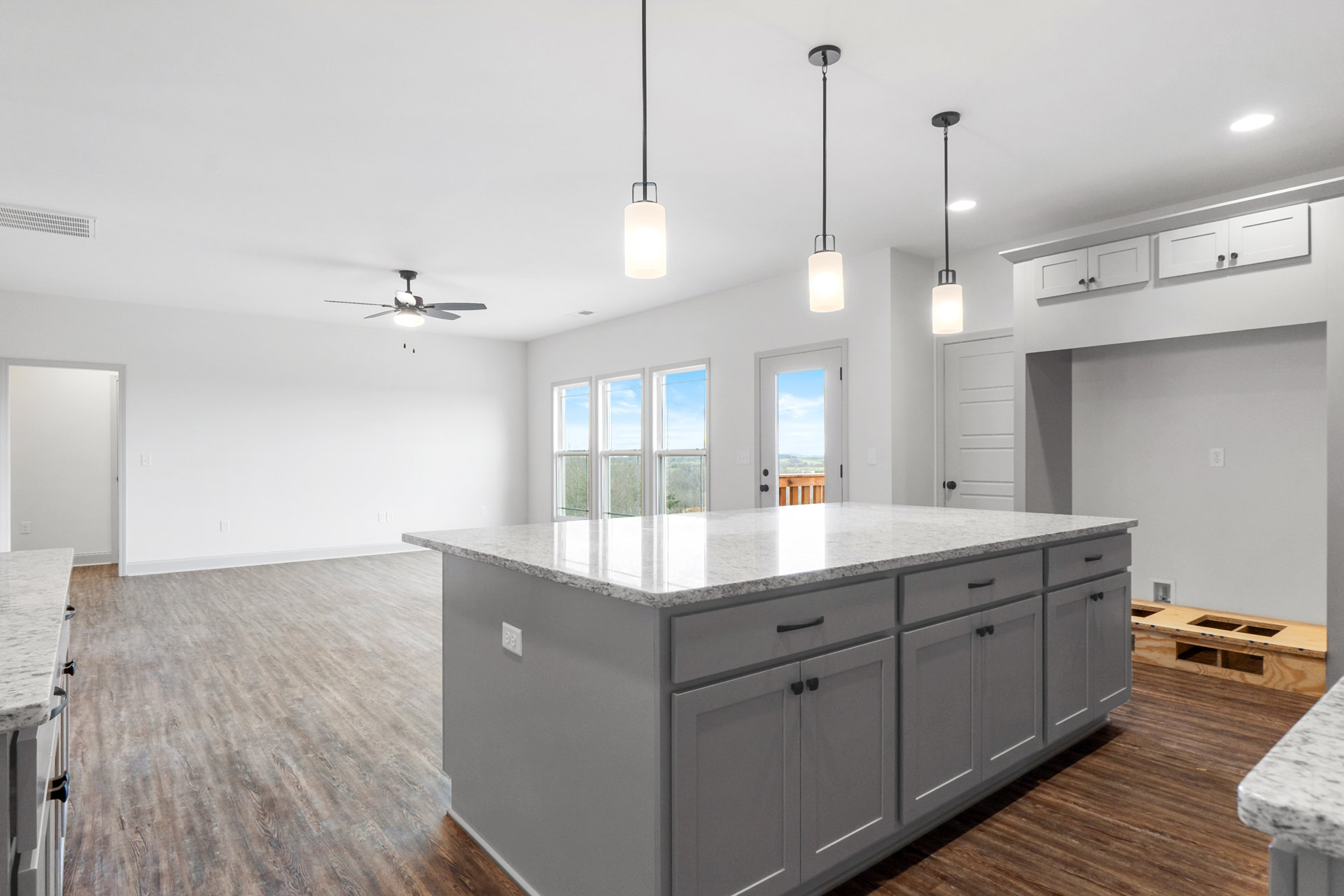 Marble-topped kitchen island with white cabinetry, stainless steel handles, built-in sink, tile flooring, and recessed ceiling lights