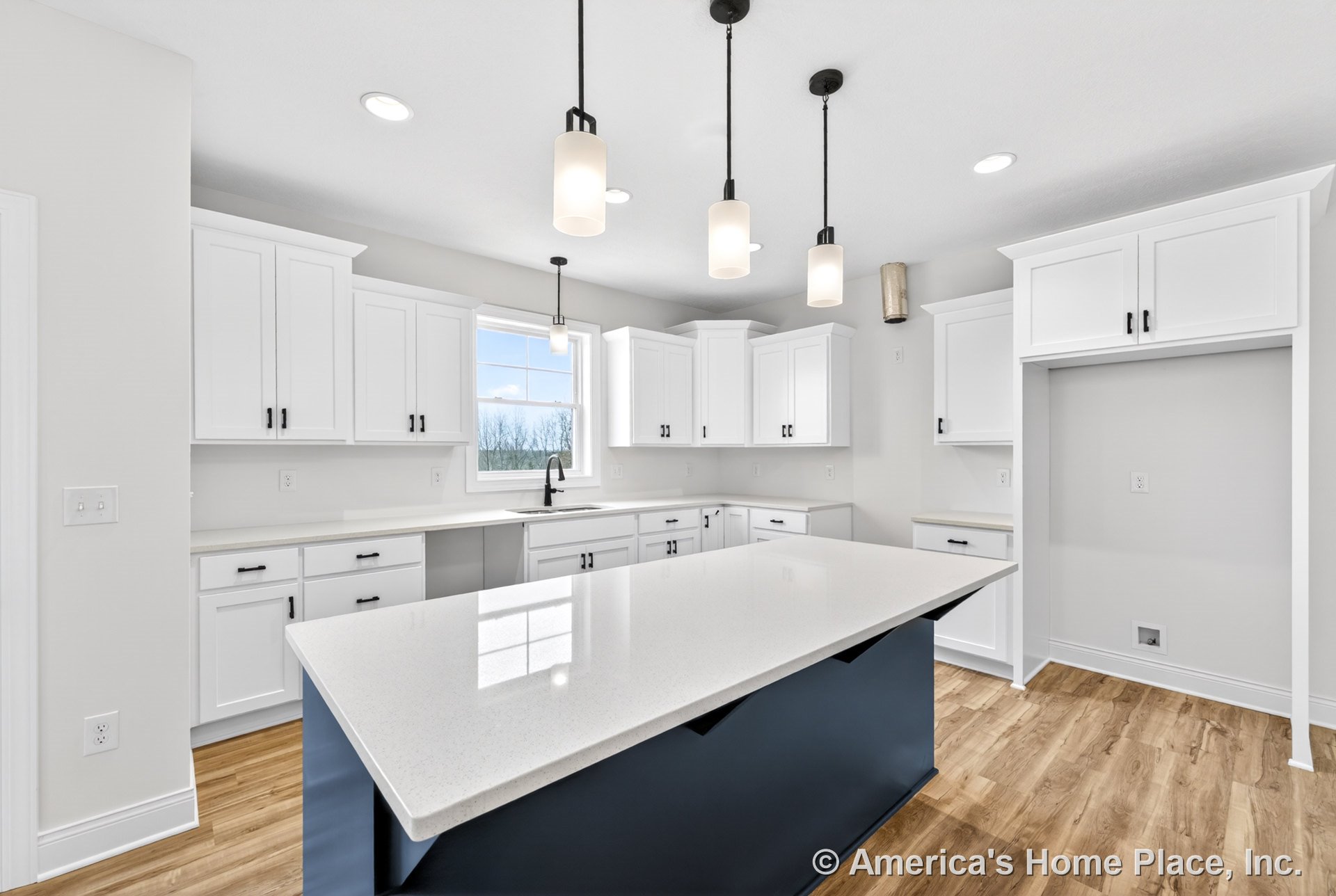 White shaker cabinets with black hardware, quartz island countertop, pendant lights above large island, wood-look flooring, window above sink, built-in ceiling lights, open kitchen