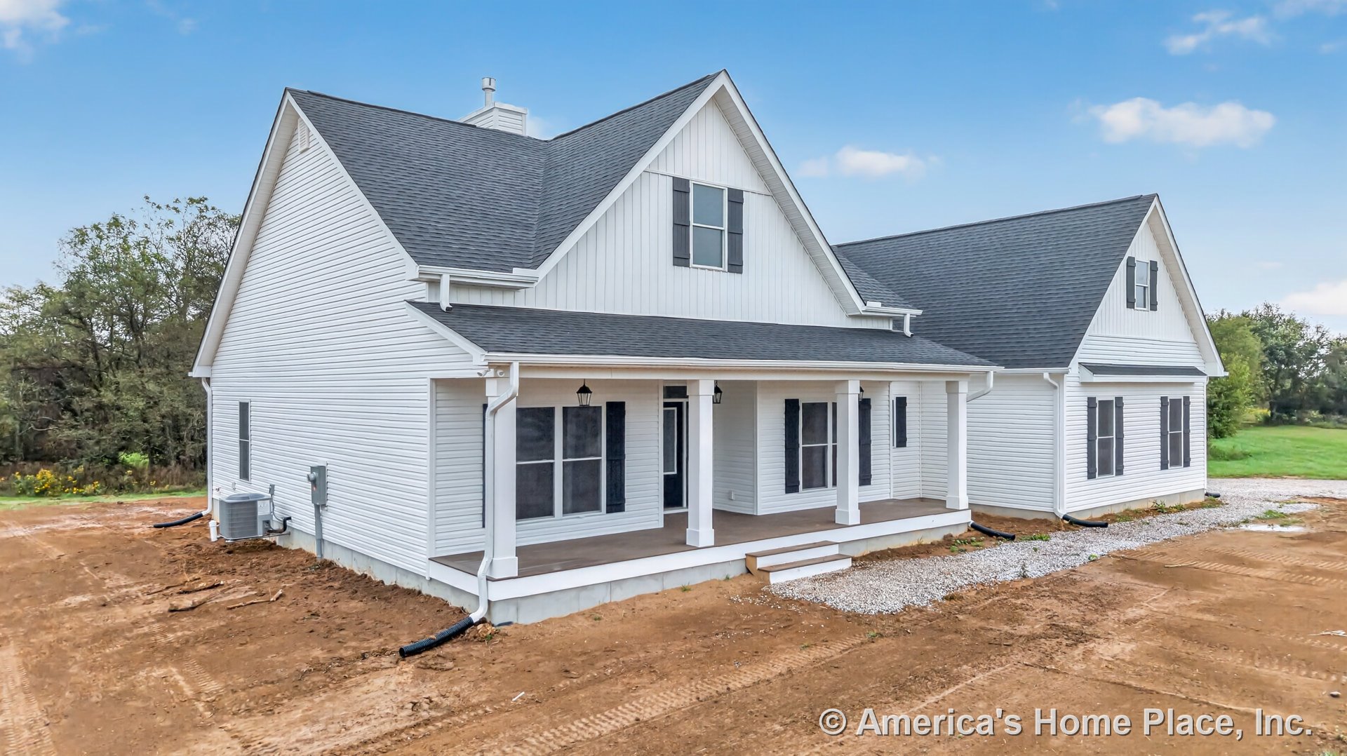 Covered front porch with white columns, white siding exterior, black window shutters, gabled roof with asphalt shingles, multiple exterior windows, outdoor ceiling lights, and