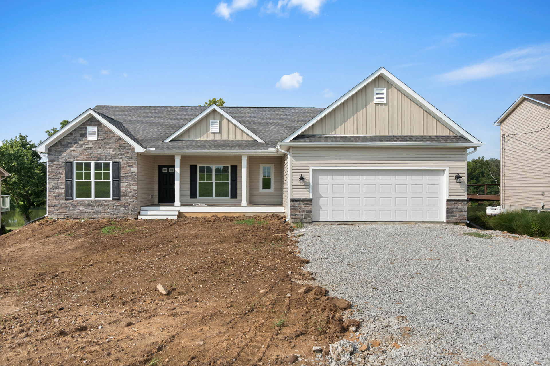 Two-story home with white siding, black shutters, white-framed windows, brown shingle roof, white garage door, black front door, and paved driveway surrounded by green lawn and