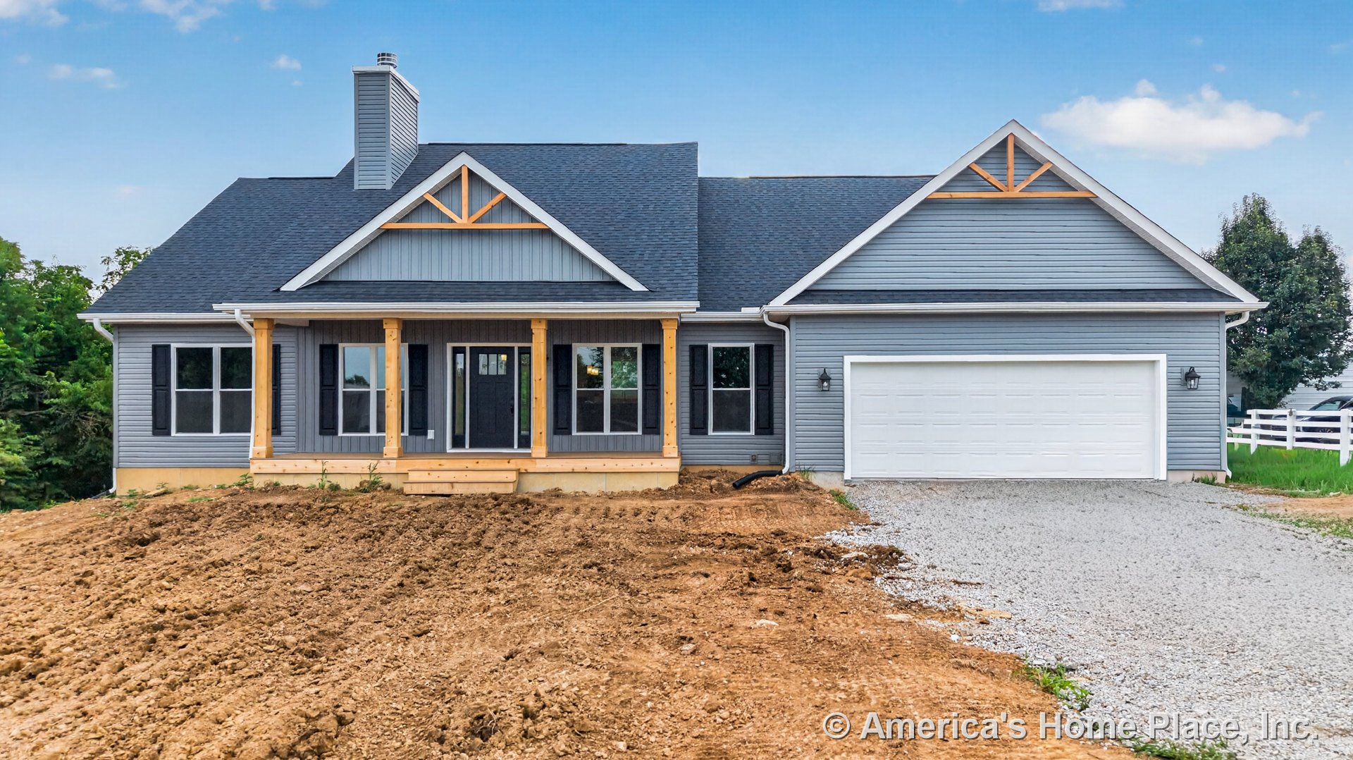 Covered front porch with wood columns, gray vinyl siding, black window shutters, wood trim accents, white two-car garage door, asphalt shingle gabled roof, brick chimney, permanent