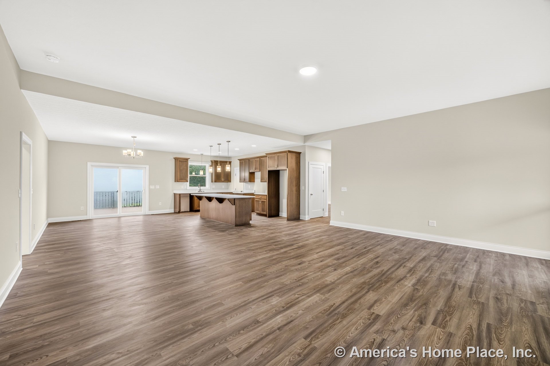 Open concept living room and kitchen with wood-look plank flooring, shaker-style cabinets, large kitchen island, recessed and pendant lighting, sliding glass patio doors, and