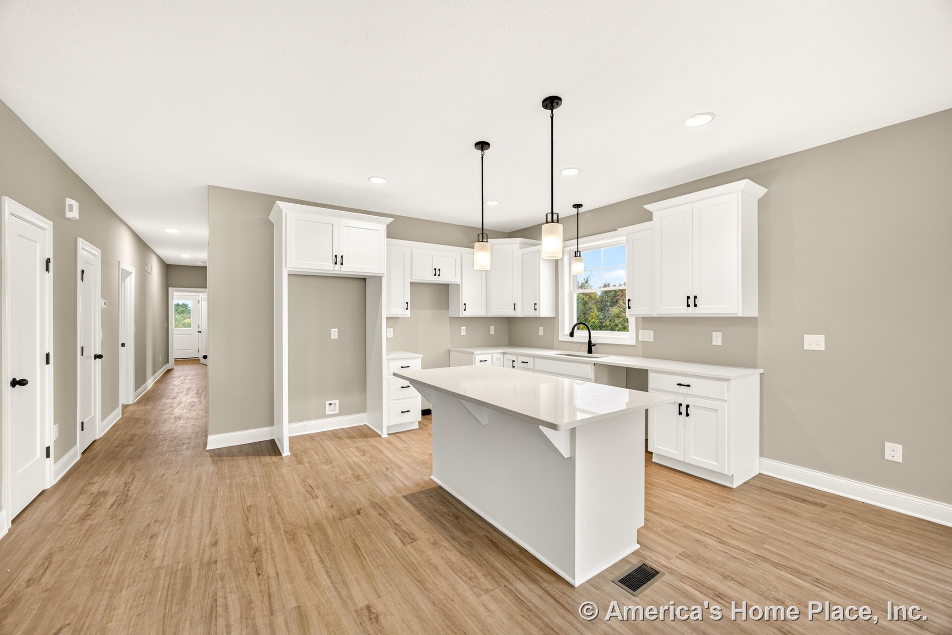White shaker cabinets with black hardware, quartz island countertop with single-handle black faucet, pendant lights above island, wood-look flooring, recessed lighting, trimmed