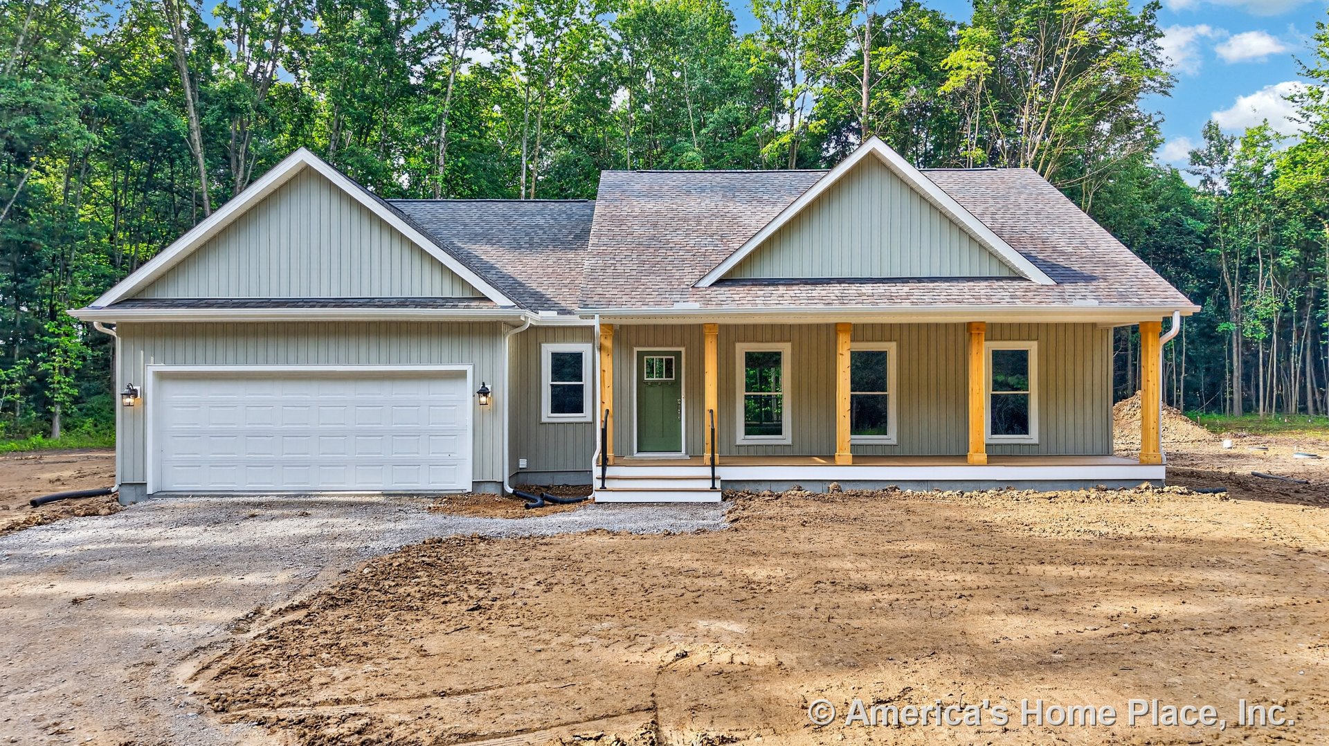 Vertical board siding exterior with covered front porch supported by wood columns, attached two-car garage with white door, front entry steps, windows, roof shingles, trim, outdoor