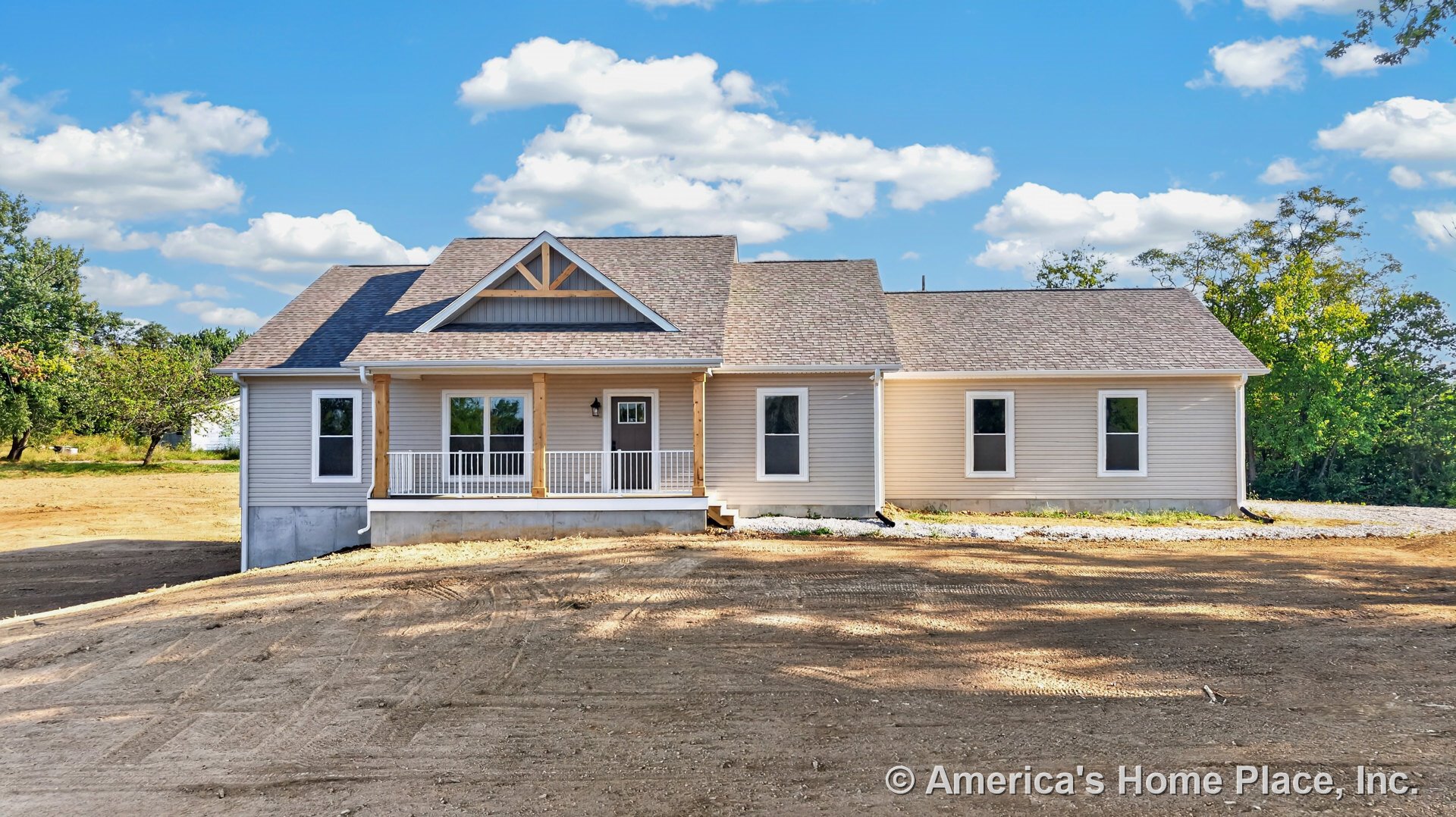 Covered front porch with exposed wood columns and white railing, gable roof with architectural shingles, vinyl siding exterior, white framed windows, glass panel front entry door