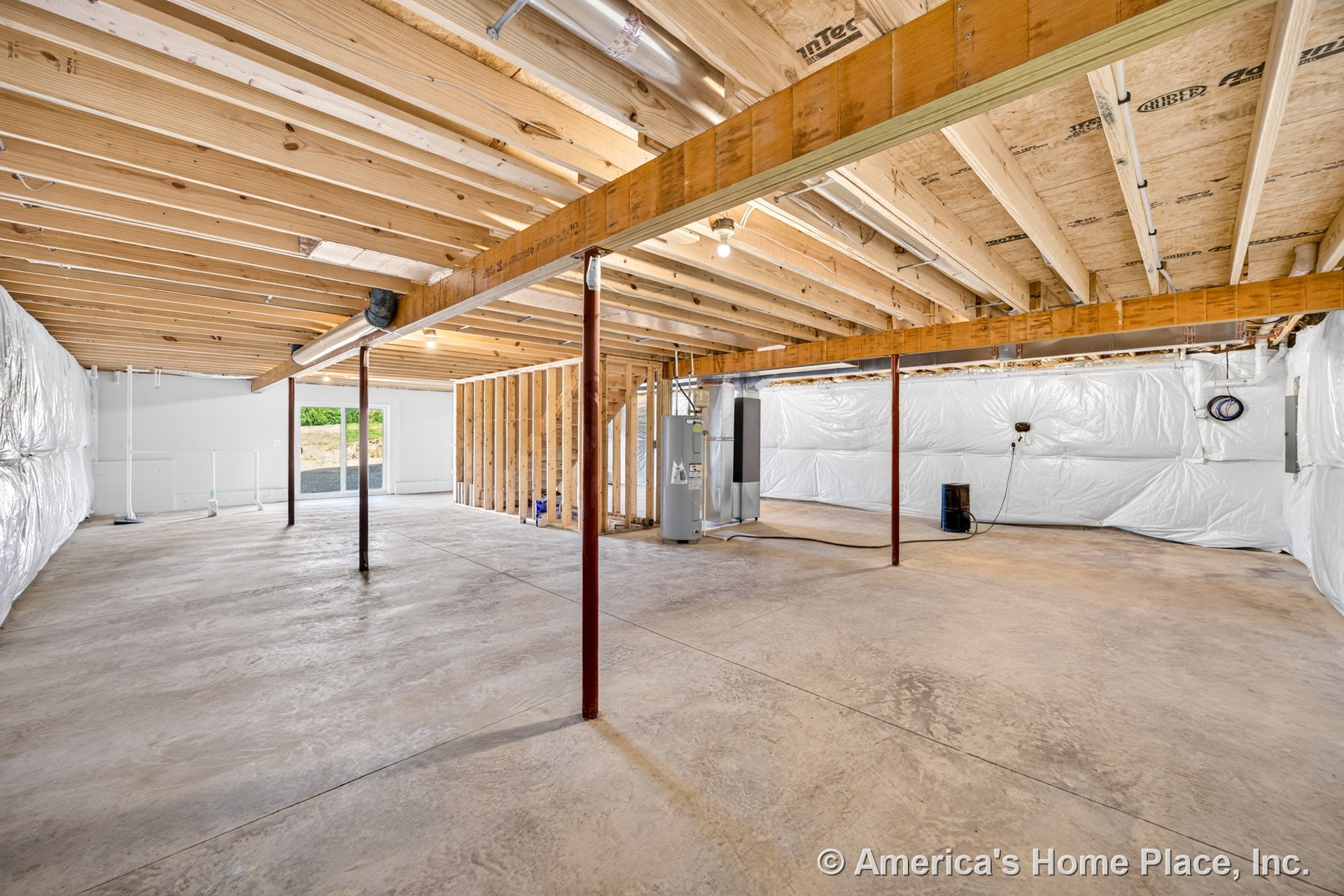 Unfinished basement with exposed wood ceiling joists, concrete slab floor, insulated plastic wall covering, metal support columns, utility area featuring a water heater, framed