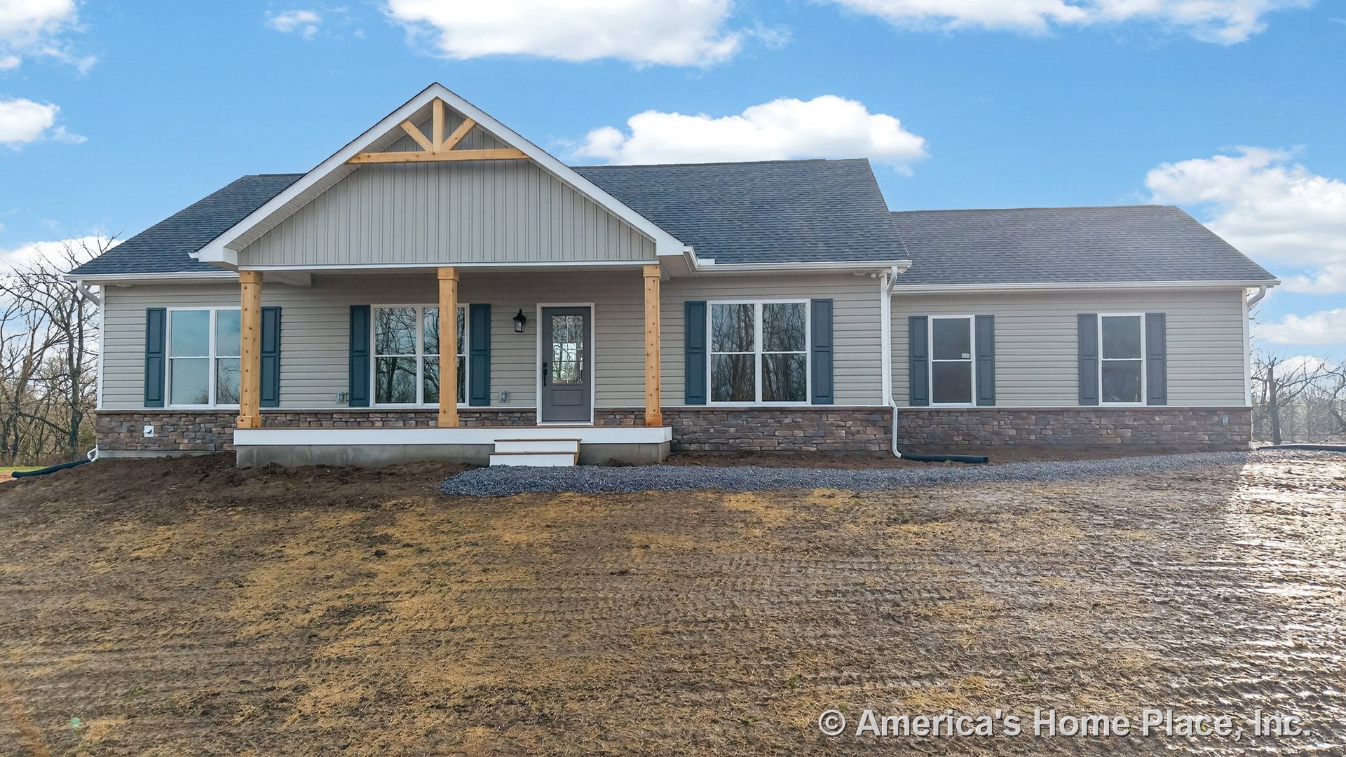 Covered front porch with wood columns and stone veneer foundation, gabled roof featuring decorative truss, vertical siding on porch gable, multiple double-hung windows with