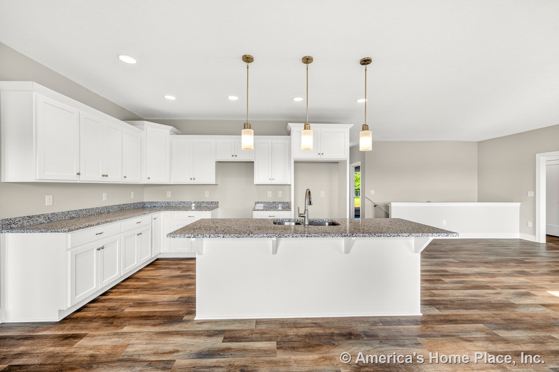 White shaker cabinets and granite countertops with built-in sink, large central kitchen island, pendant and recessed lighting, wood-look flooring, neutral walls, and modern trim in
