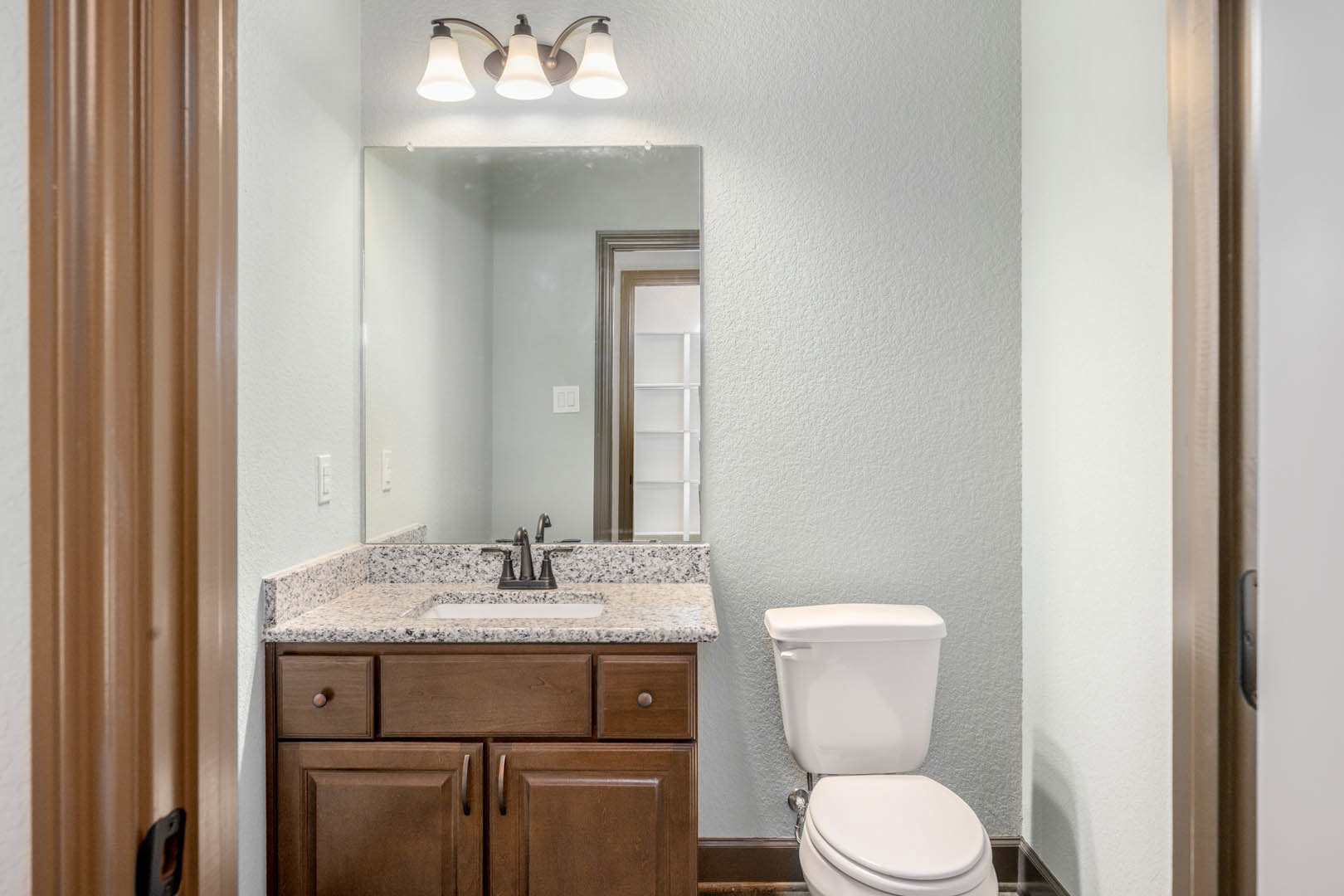 Modern bathroom with white tile walls, floating vanity with vessel sink, large frameless mirror, chrome faucet, and recessed lighting