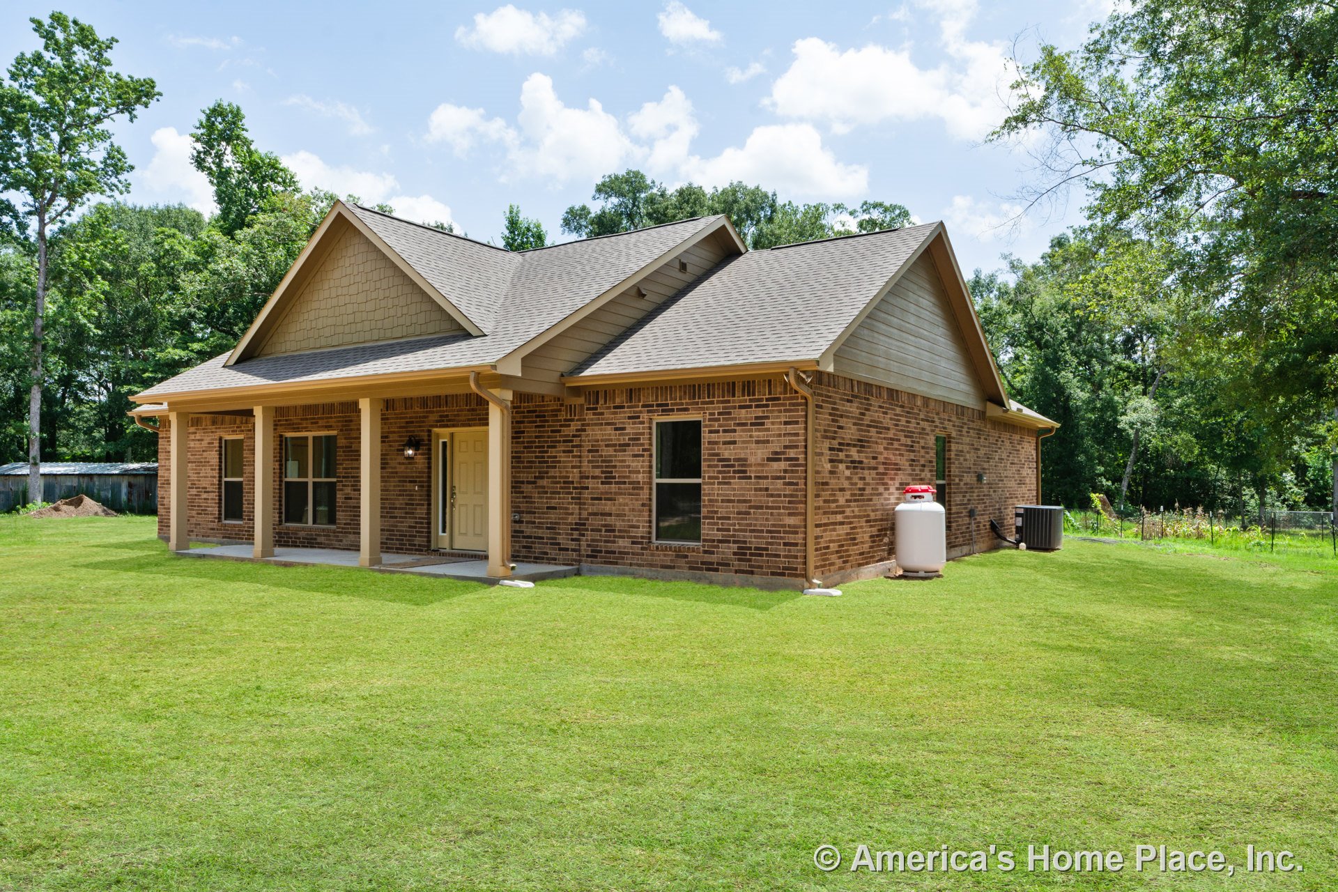 Brick siding with gabled rooflines, covered front porch, double-hung windows, tan entry door, attached gutters, and shingle roofing.