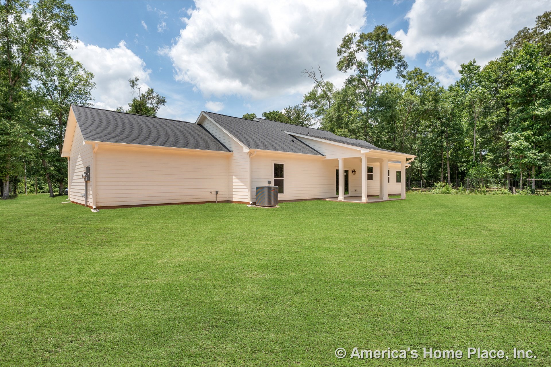 Light-colored horizontal lap siding and dark asphalt shingle roof on a single-story home with covered back porch supported by columns, multiple windows, central HVAC unit, outdoor