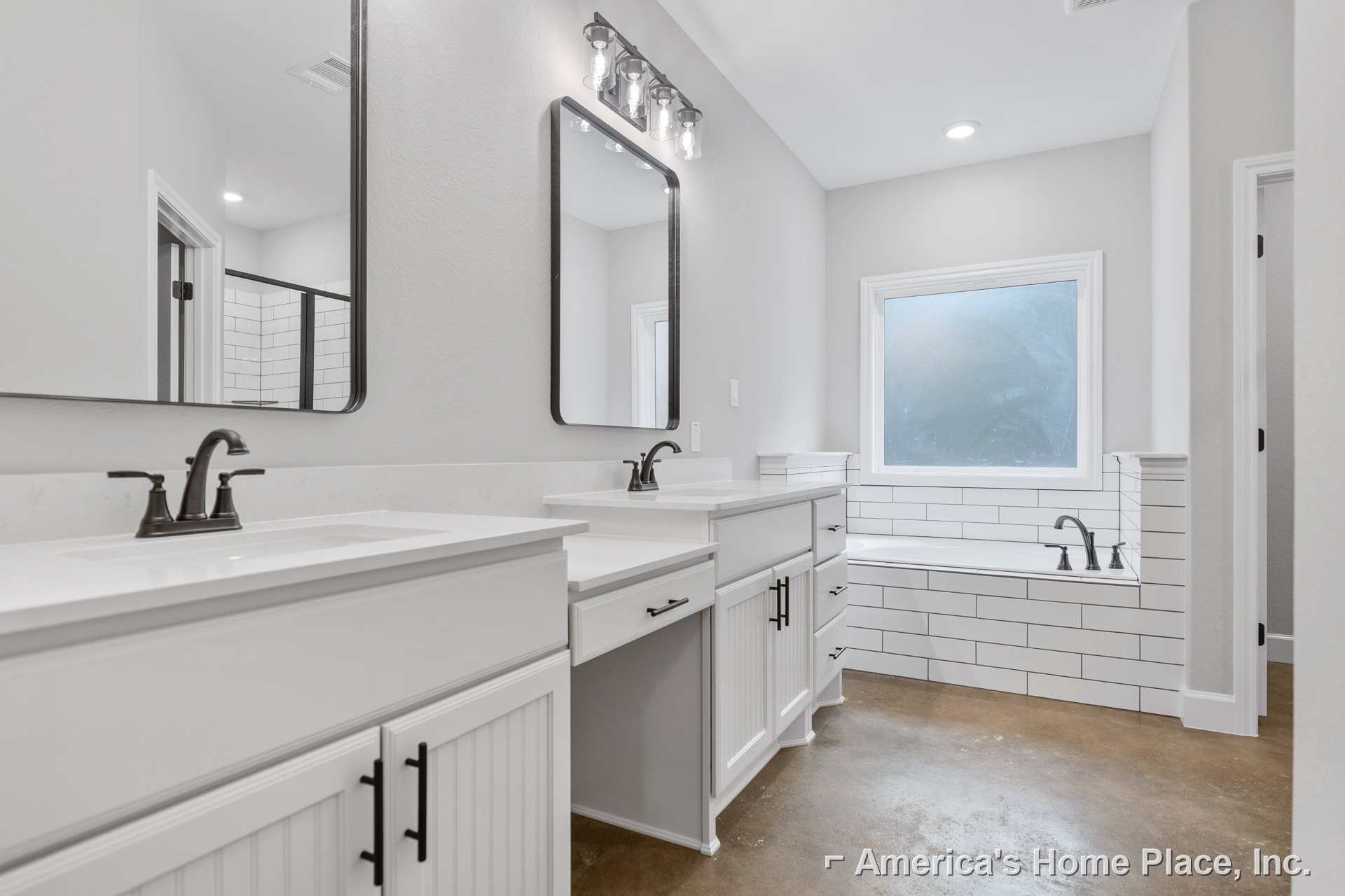 White bathroom with dual sinks, chrome faucets, white cabinetry, frosted glass window, large wall mirror, and light tile flooring