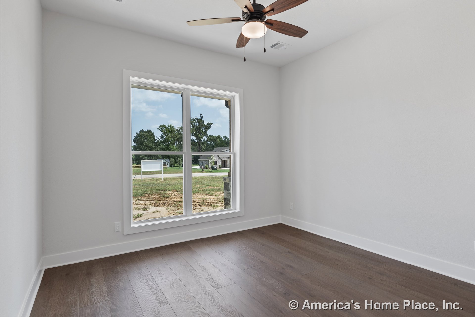 Large double window with white trim, wood plank flooring, white baseboards, ceiling fan with integrated light, smooth white walls, rectangular bedroom layout filled with natural