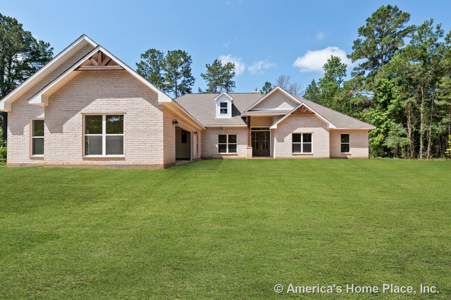 Light brick exterior with gabled rooflines and dormer, large double-pane windows, covered entry porch, white trim accents, and attached garage.