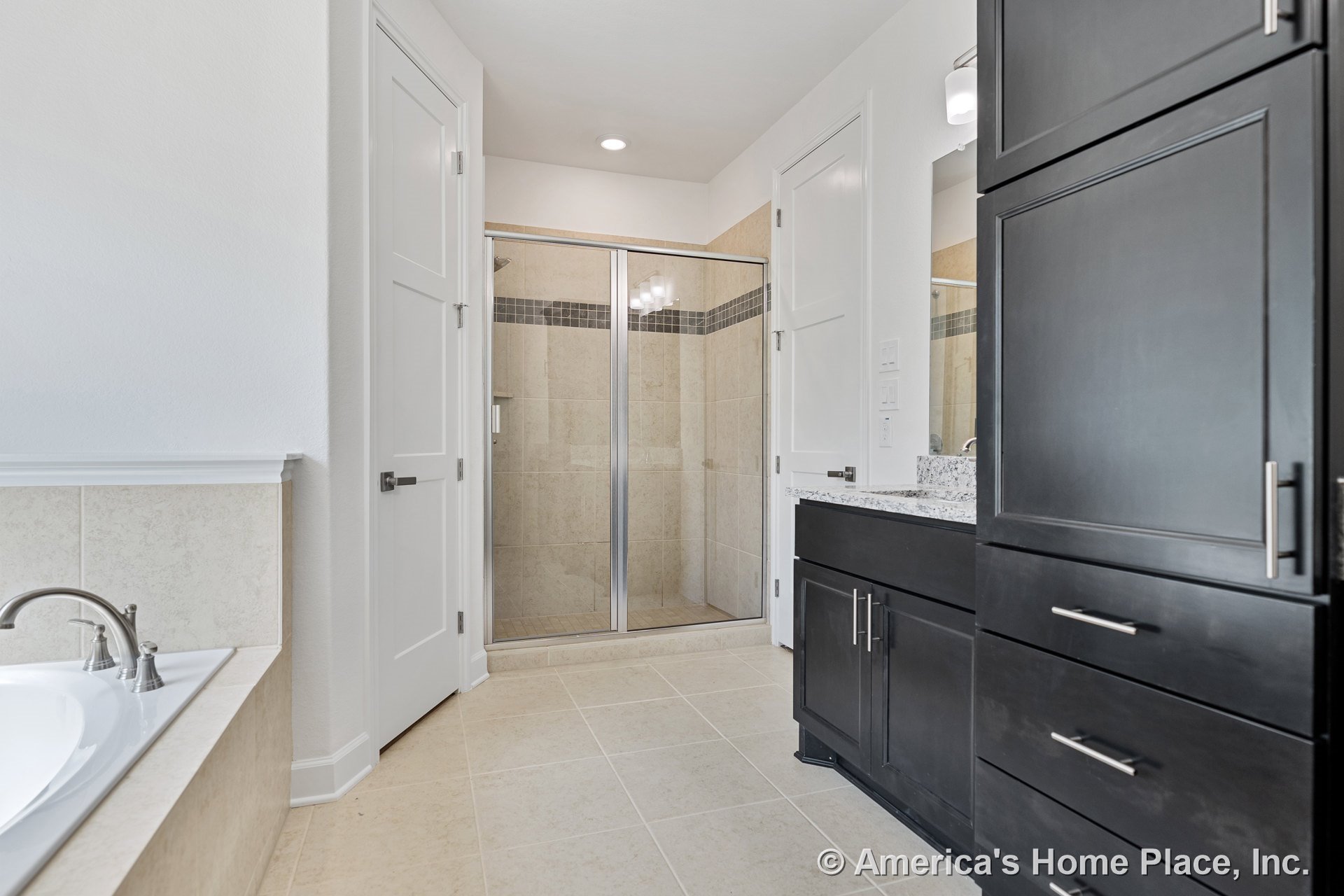 Walk-in tile shower with glass doors, built-in bathtub with tile surround, dark wood vanity cabinets topped with granite countertop, recessed ceiling lighting, tile flooring, white