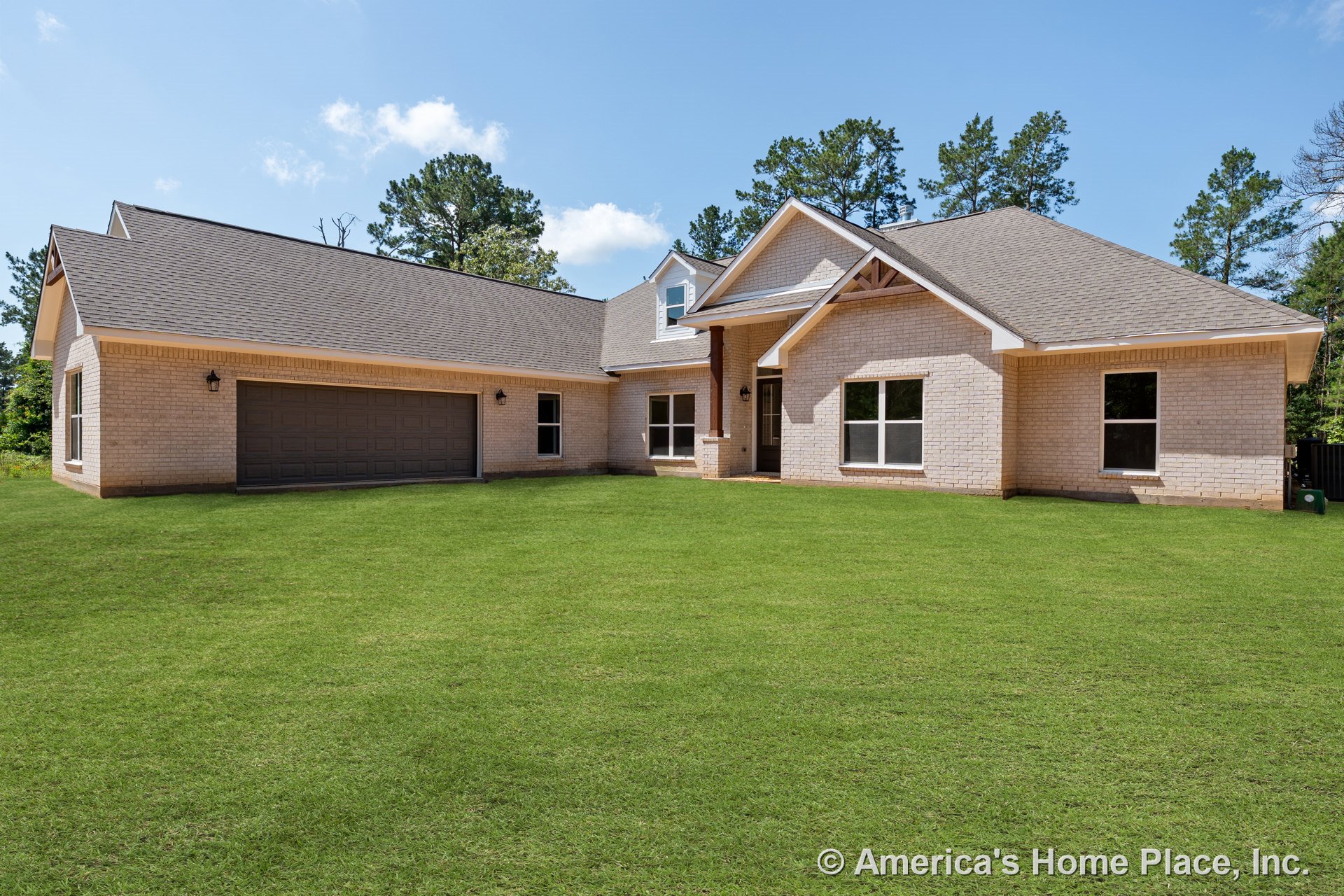 Light brick exterior with gabled roof, double garage door, covered entry porch, large front windows, trimmed eaves, and permanent lighting along the front yard.