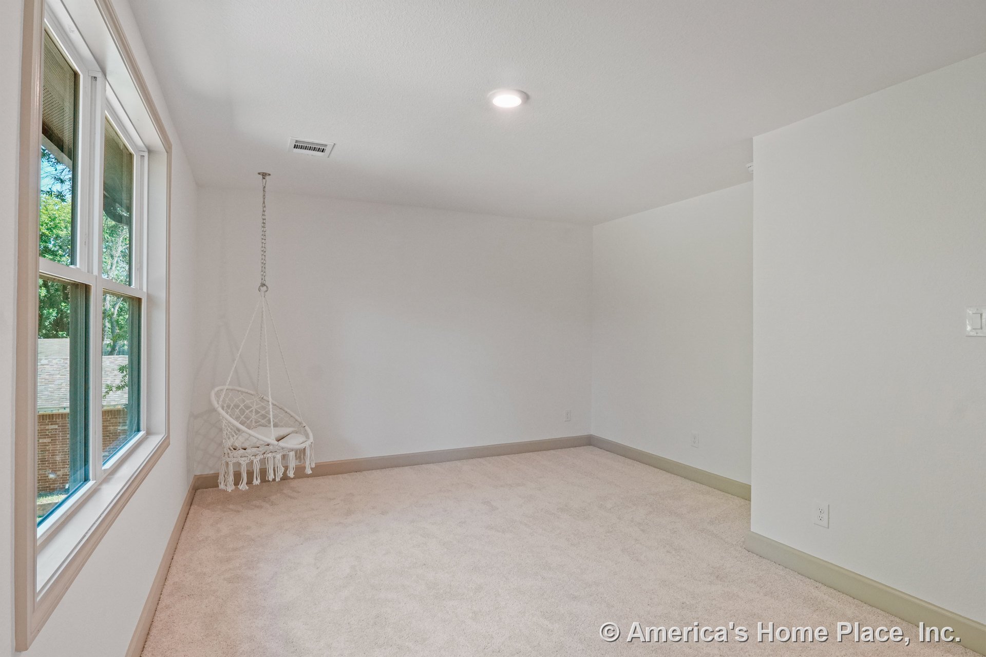 Carpeted bedroom with large double window, recessed ceiling lighting, neutral wall paint, trimmed baseboards, ceiling vent, and window trim.