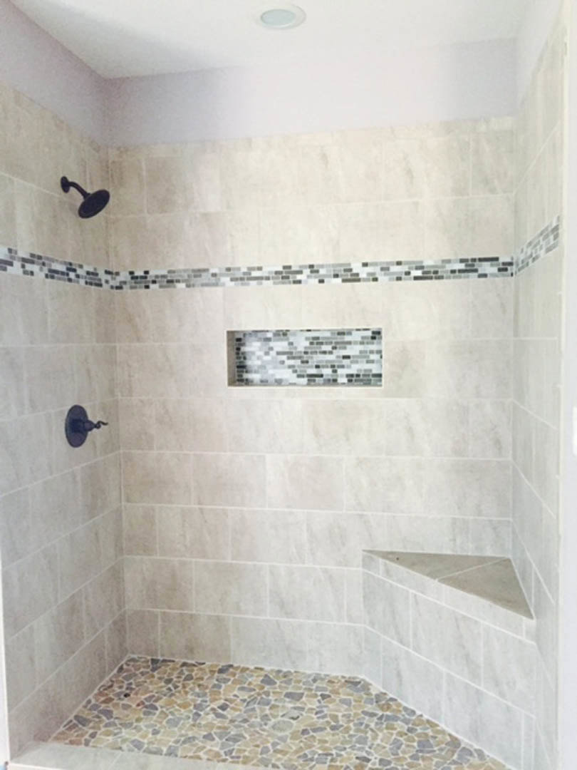 Walk-in shower with marble tile walls, built-in bench, and round shower head