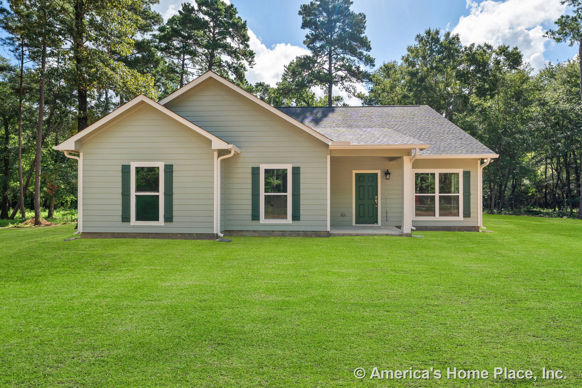 Light green horizontal lap siding with matching shutters, green front door, covered entry porch, double-hung windows, white exterior trim, shingle roof, and gutters on a