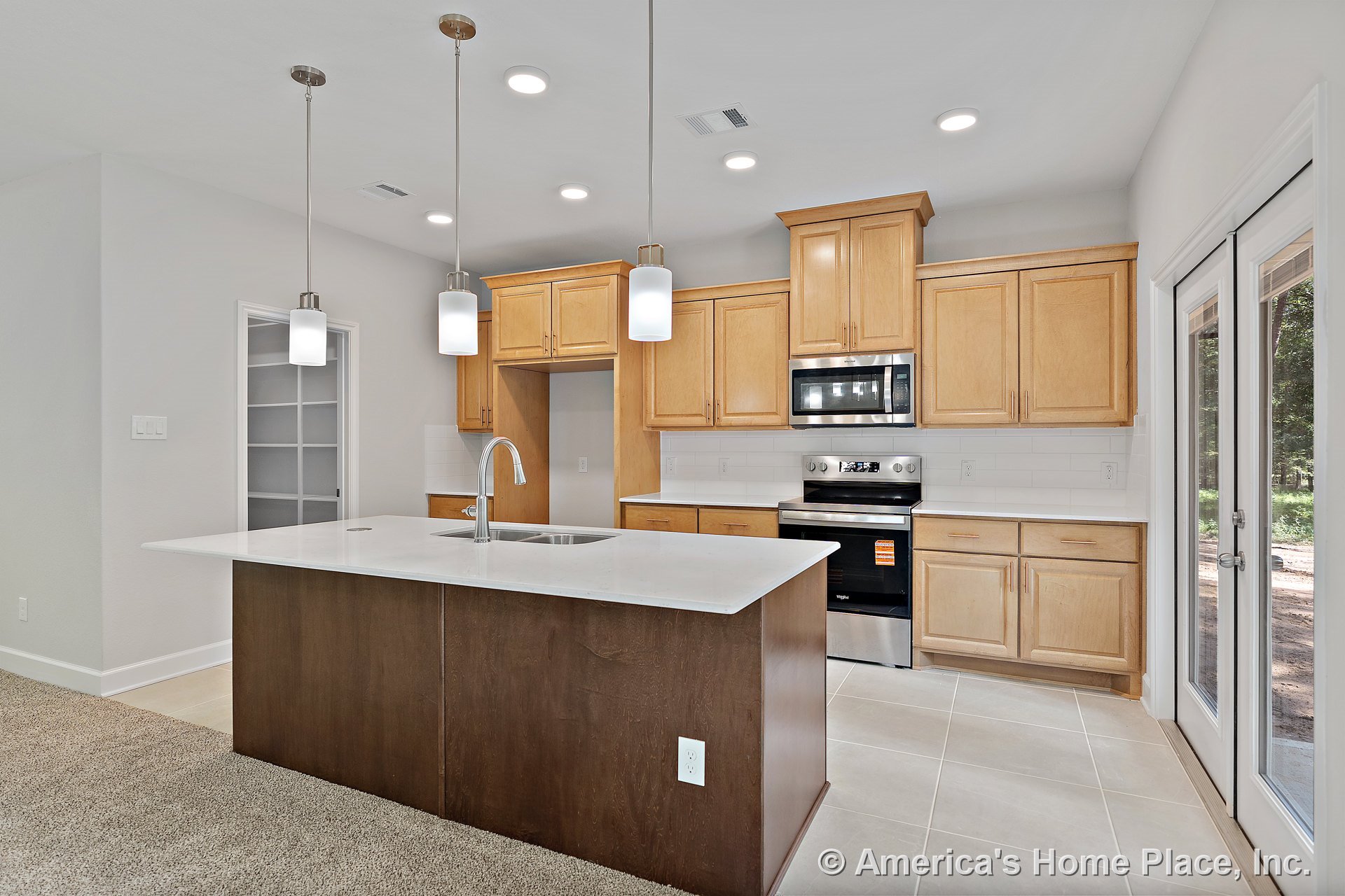 Light wood kitchen cabinetry with built-in pantry shelving, central island topped with quartz countertop, stainless steel appliances, subway tile backsplash, pendant and recessed