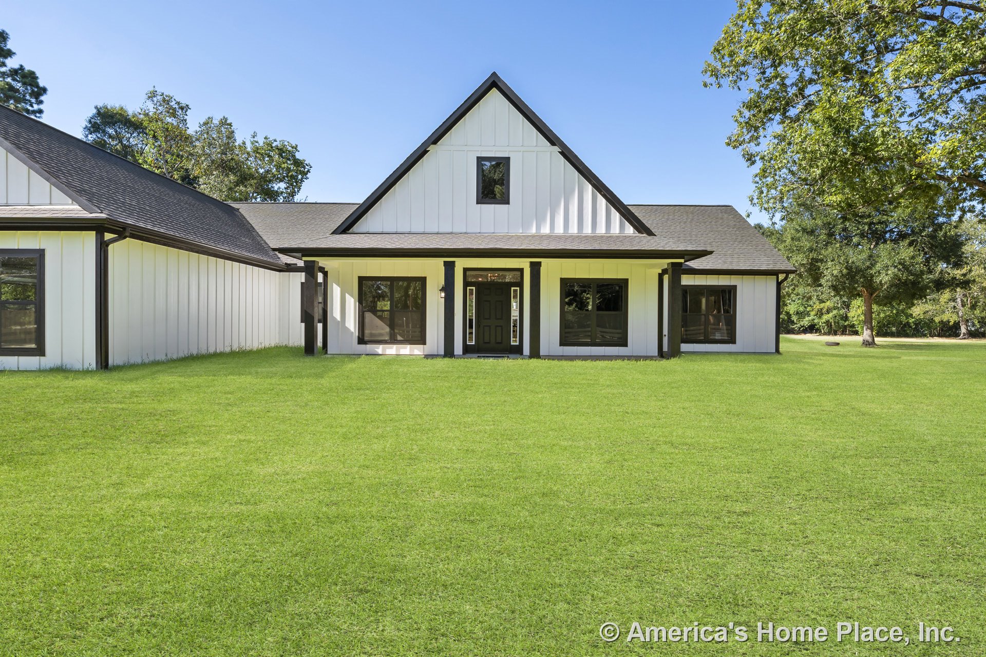 Board and batten siding with dark trim, covered front porch beneath a gabled roof, multiple windows, and central front door on modern farmhouse exterior