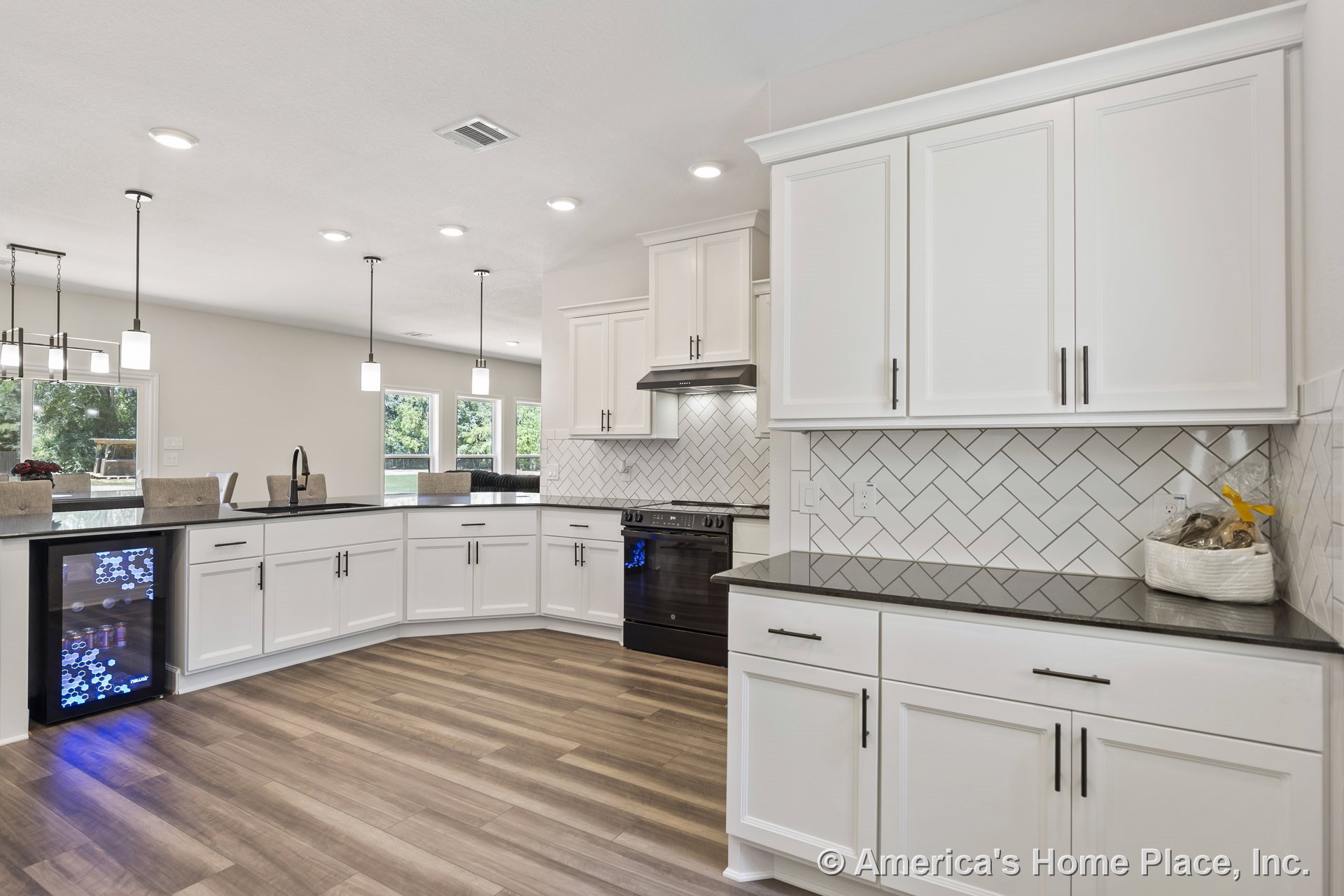 White shaker cabinets with black stone countertops, herringbone tile backsplash, pendant lighting, wood-look flooring, built-in wine fridge, stainless range hood, recessed