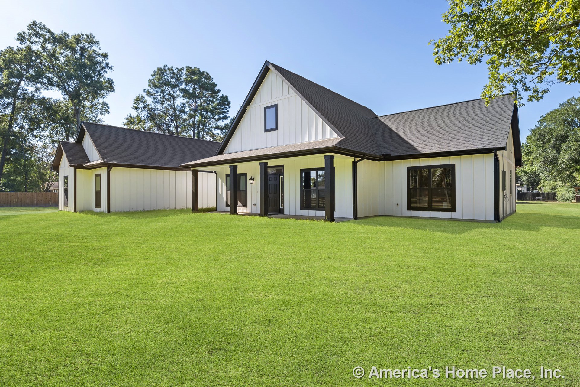 Board and batten siding with contrasting dark window trim, covered front porch supported by square columns, gabled roof, large windows, modern farmhouse entry door, permanent