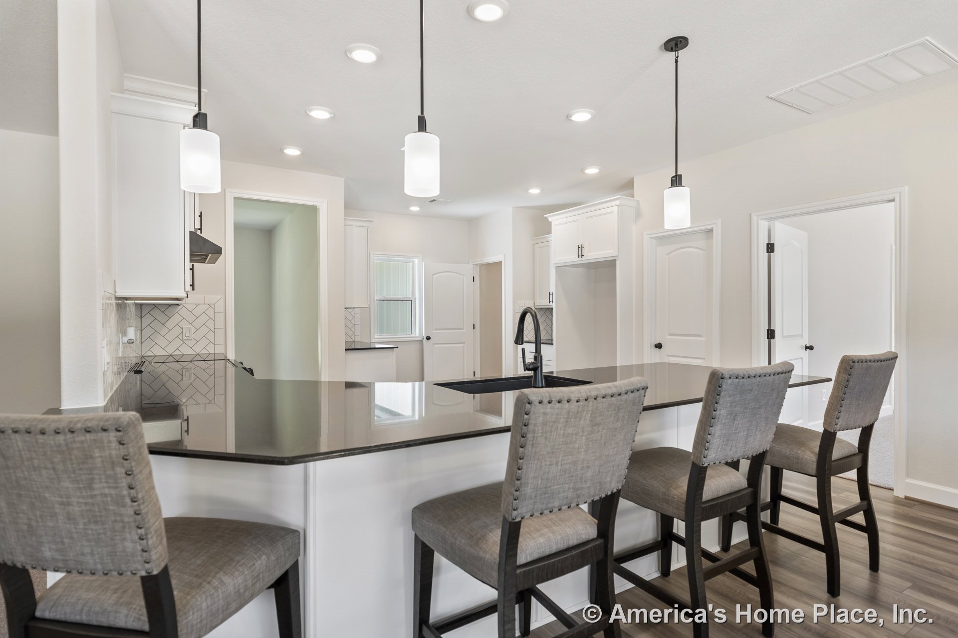 White shaker cabinets with black stone island countertop, herringbone tile backsplash, pendant lights above the island, recessed ceiling lighting, wood-look flooring, built-in