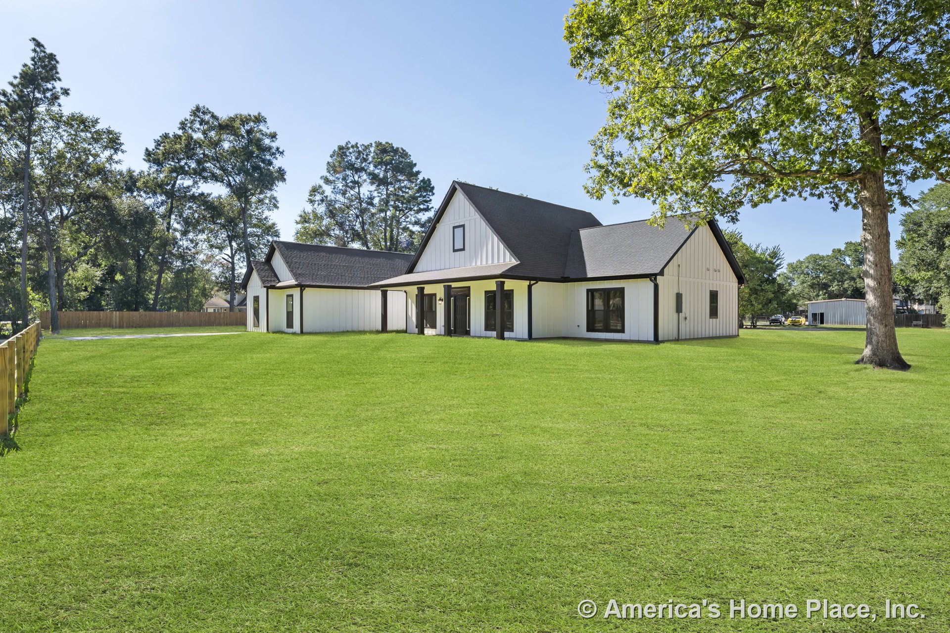 Modern farmhouse exterior with white board and batten siding, black trim and black framed windows, covered front porch with black exterior doors, prominent gabled rooflines, and