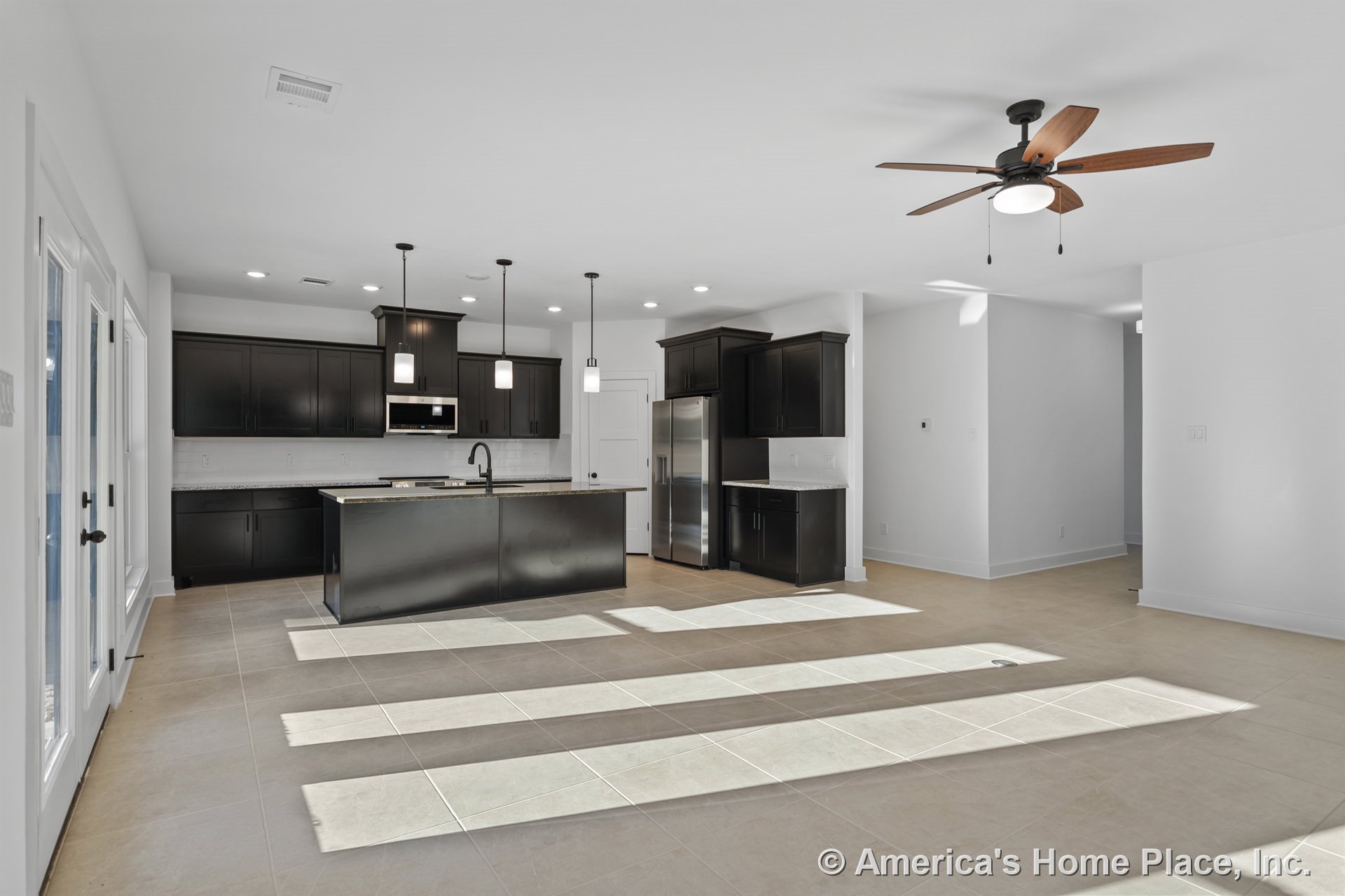 Open concept kitchen with dark wood cabinetry, granite countertops, stainless steel appliances, pendant lights above a central island, tile flooring, ceiling fan, recessed