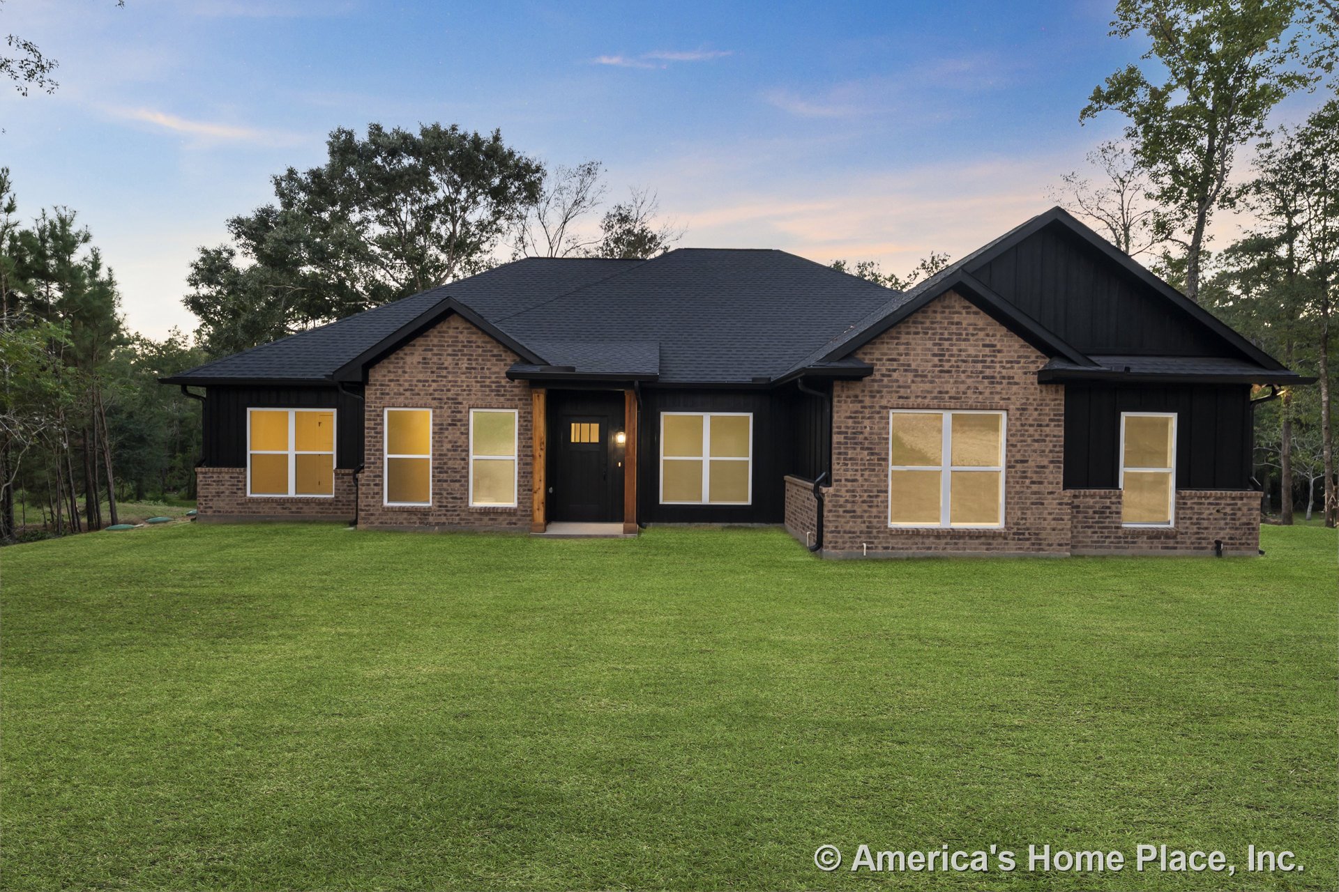 Single-story home with brick facade and black siding accents, large grid windows, covered front porch with wooden entry columns, hip roof design, modern trim, and prominent entry