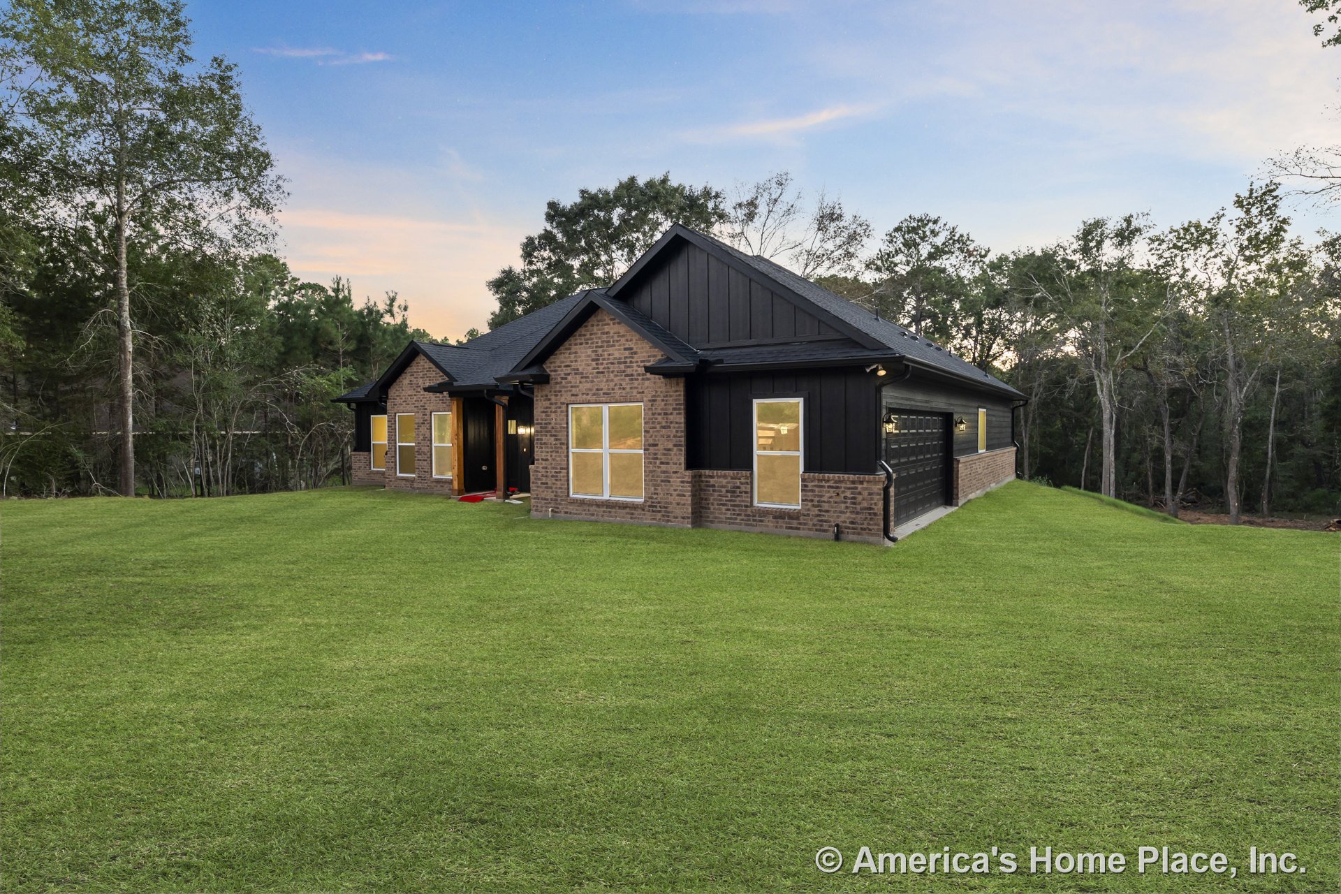 Single-story brick home with black trim, large windows, attached two-car garage, covered front entry, gabled roof, and permanent exterior lighting.