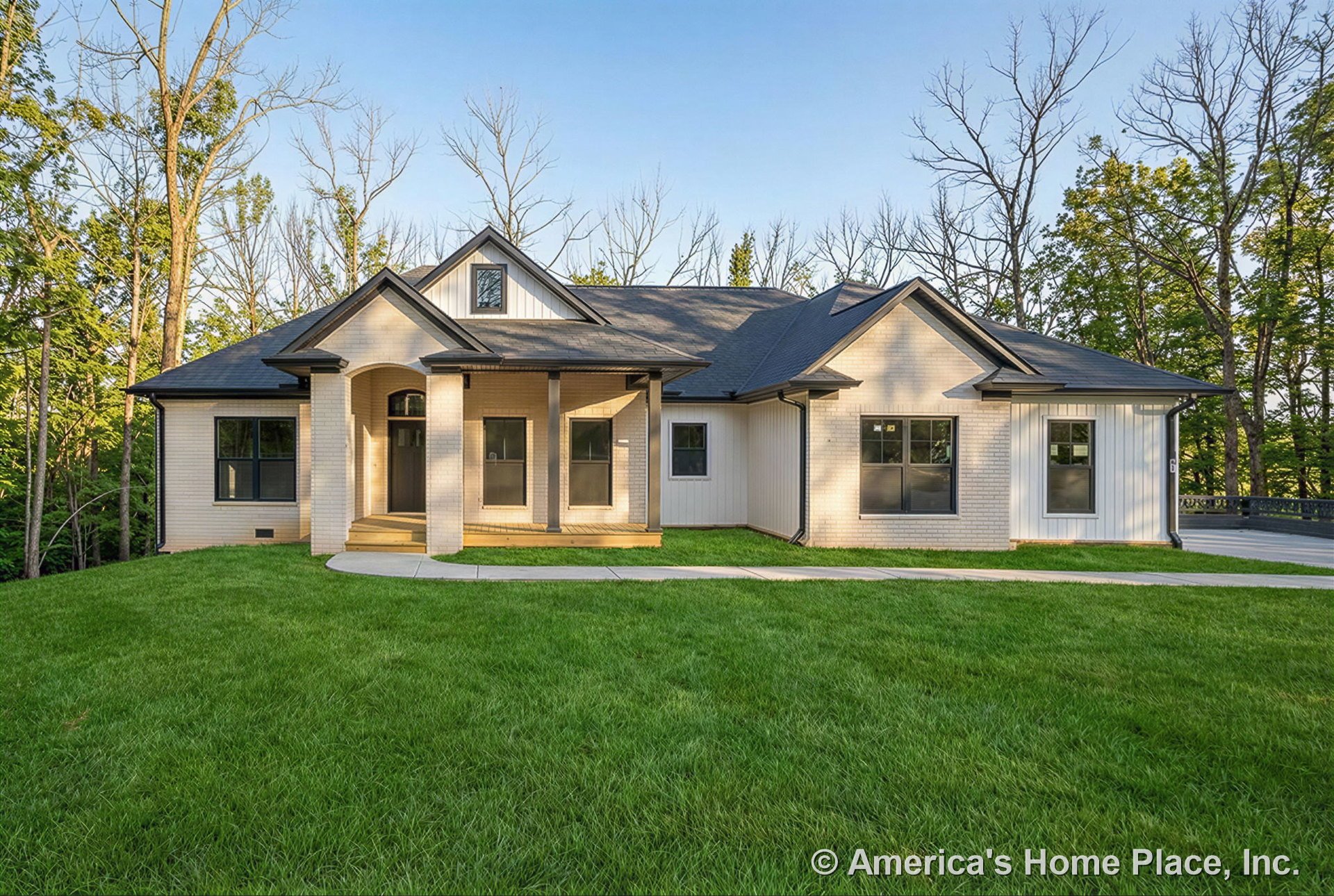 Light brick exterior with black window trim, multiple gabled rooflines, covered front porch supported by columns, large windows, and concrete walkway leading to the entry.