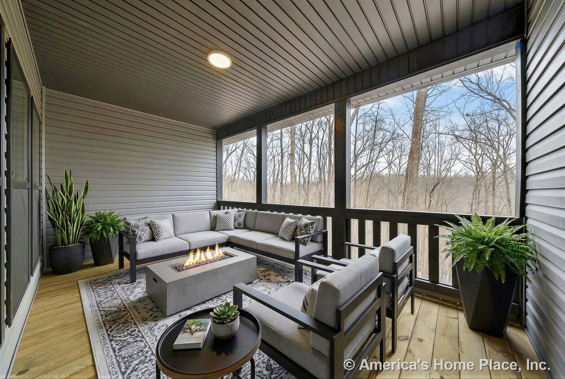 Covered screened porch with wood plank flooring, horizontal siding walls, built-in ceiling light, dark trim and railing, and outdoor ceiling panels.