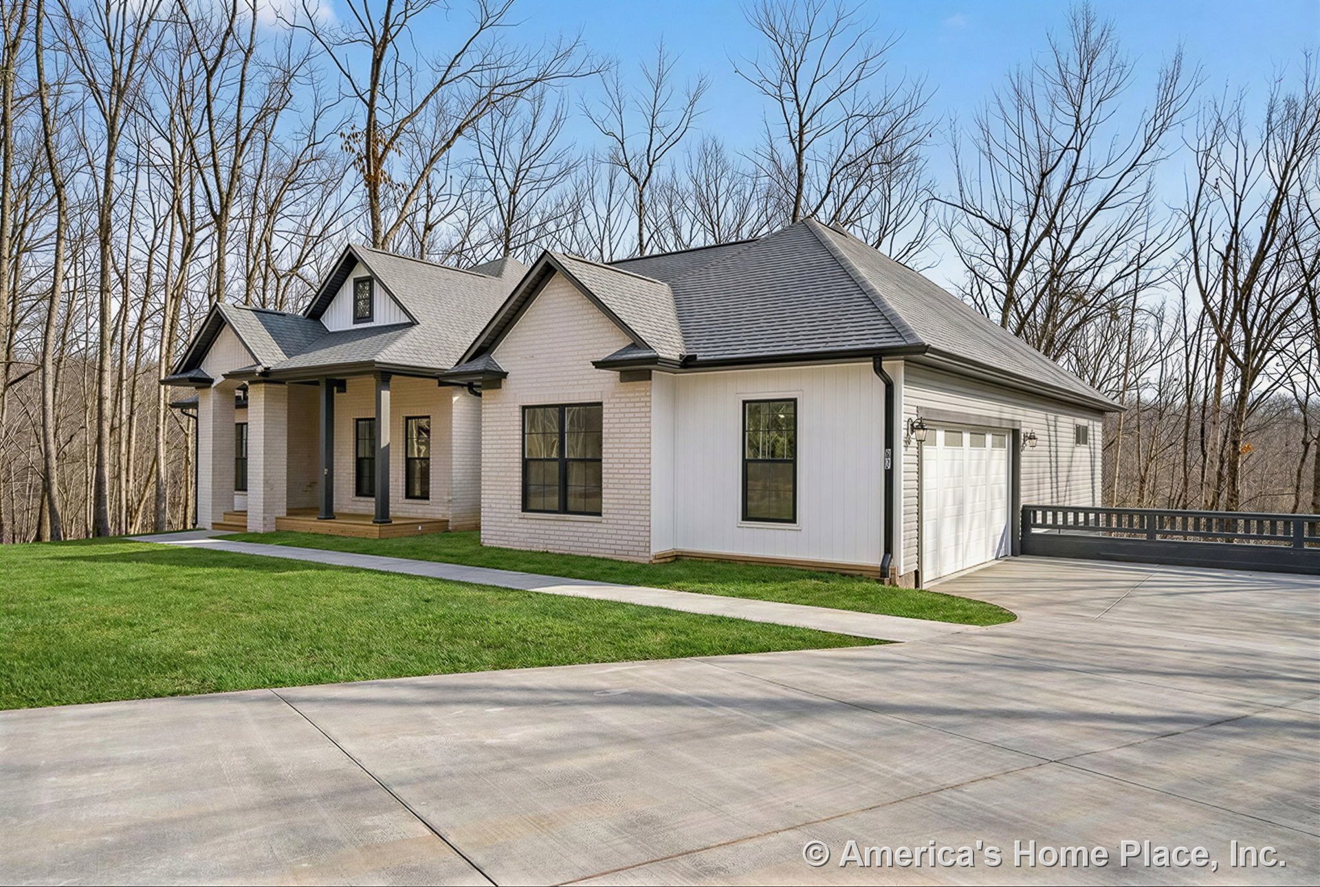 Covered front porch with white brick and siding exterior, black window trim, attached two-car garage with paneled doors, concrete driveway, gabled roof, porch columns, and exterior
