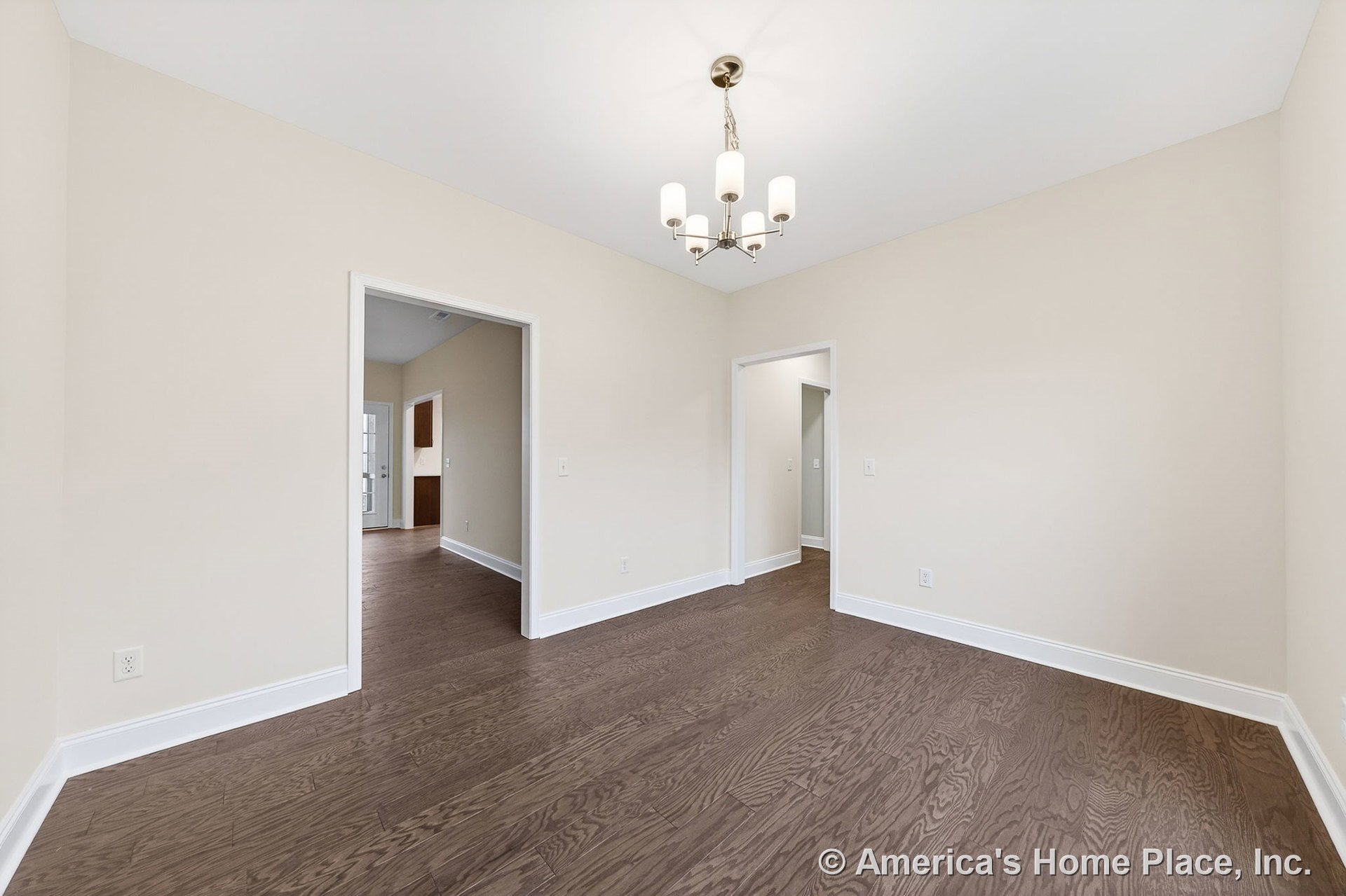 Light beige walls with white baseboards and trim, dark wood flooring, flat white ceiling, modern chandelier, and open doorways connecting transitional residential space.