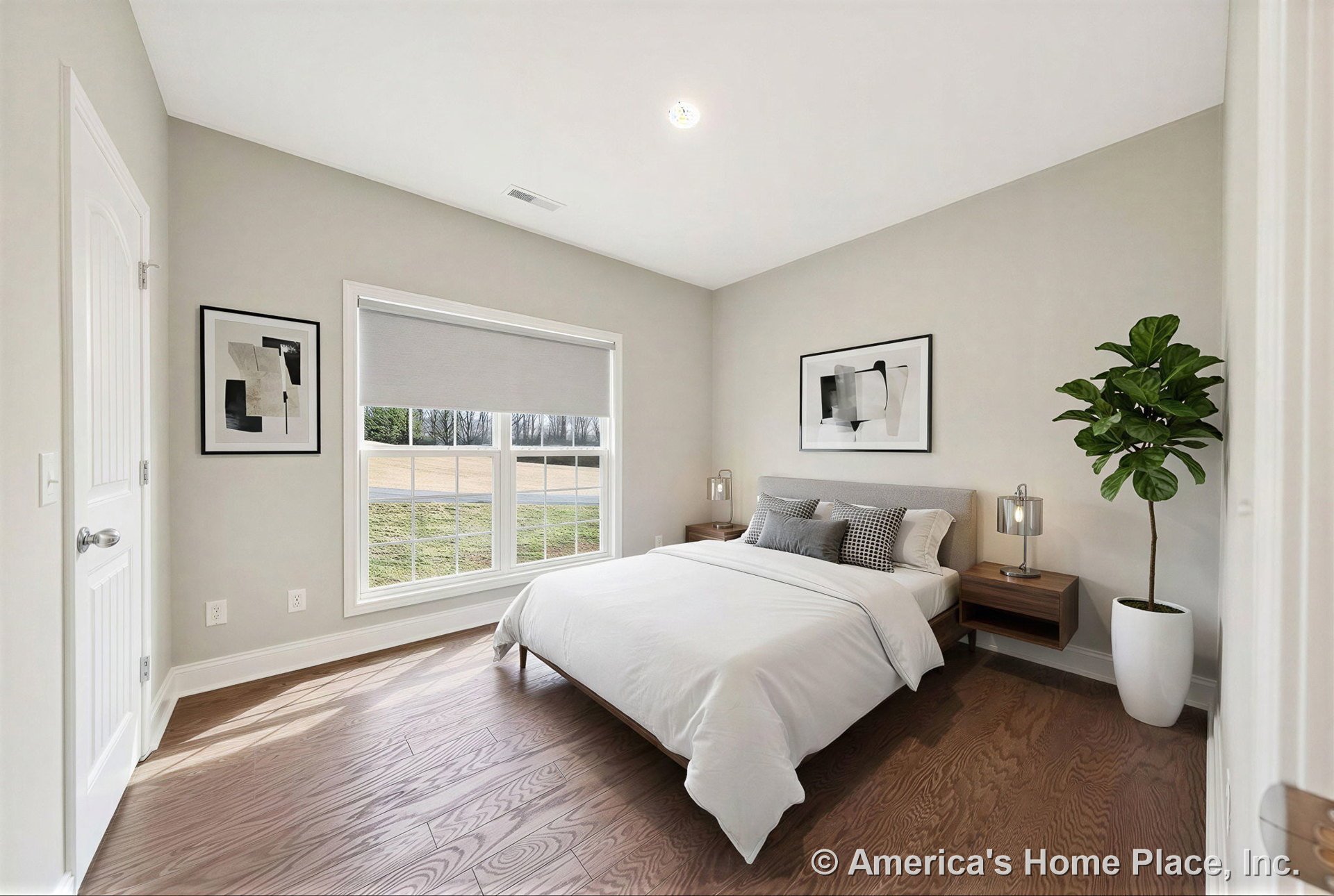 Wide plank hardwood flooring, large double window with decorative trim, paneled interior door, neutral painted walls, recessed ceiling light, and baseboard trim in a spacious