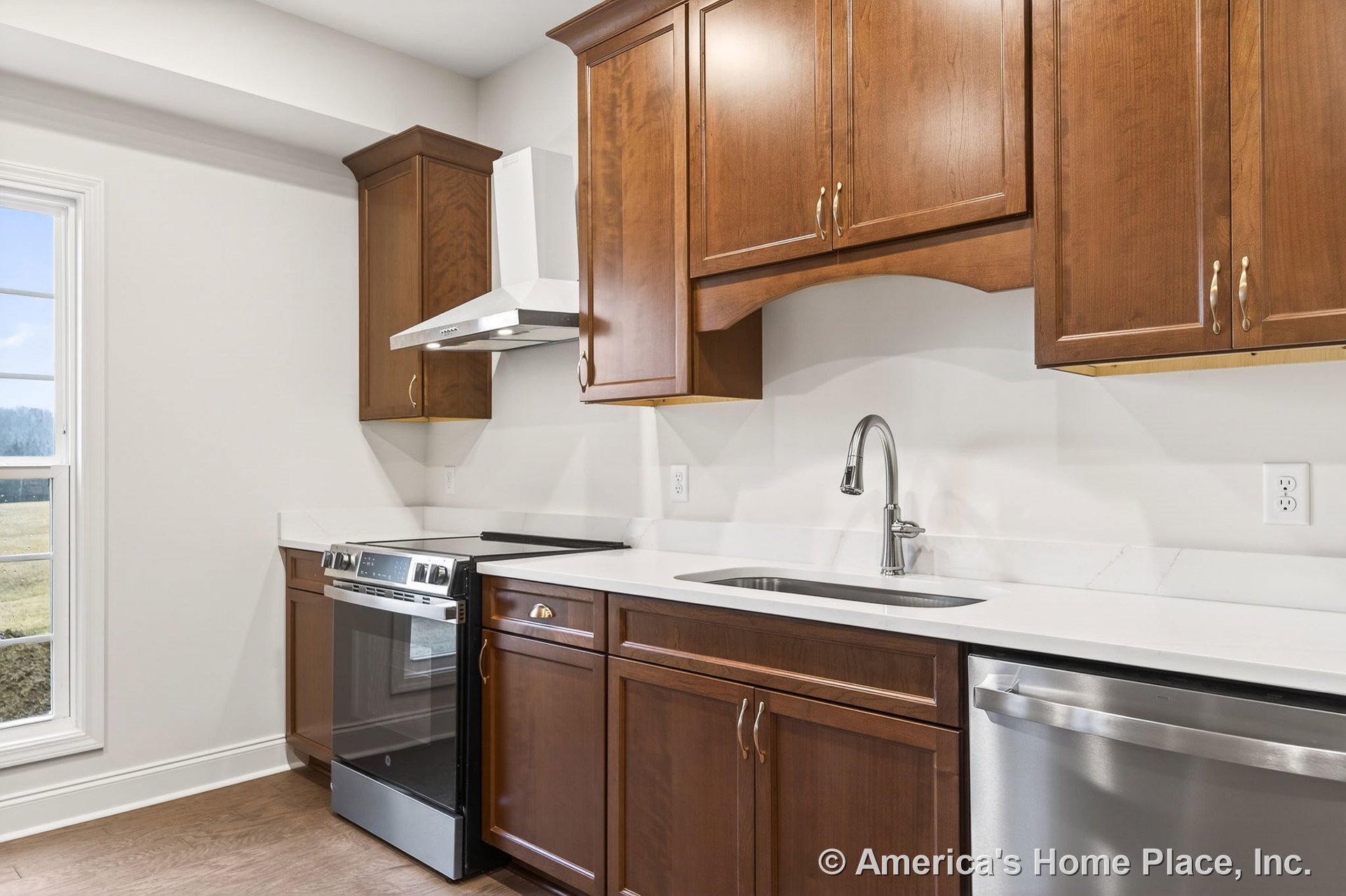 Wood cabinetry with upper and lower storage, white quartz countertops, stainless steel electric range and dishwasher, undermount sink with chrome faucet, vent hood above stove