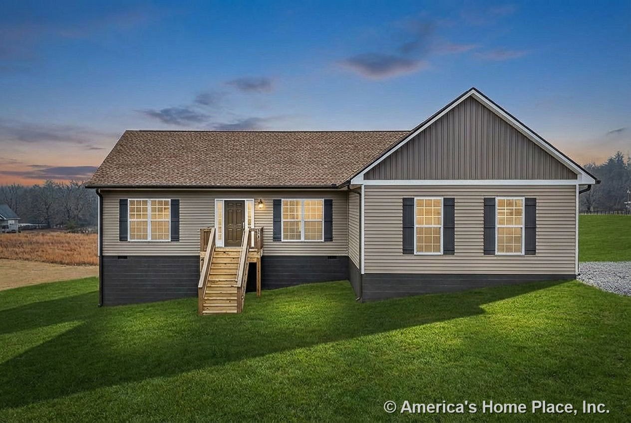 Beige vinyl siding exterior with black shutters, wooden front porch and stairs, gable roof, double-hung windows, exterior wall-mounted light, and white trim in a rural setting.