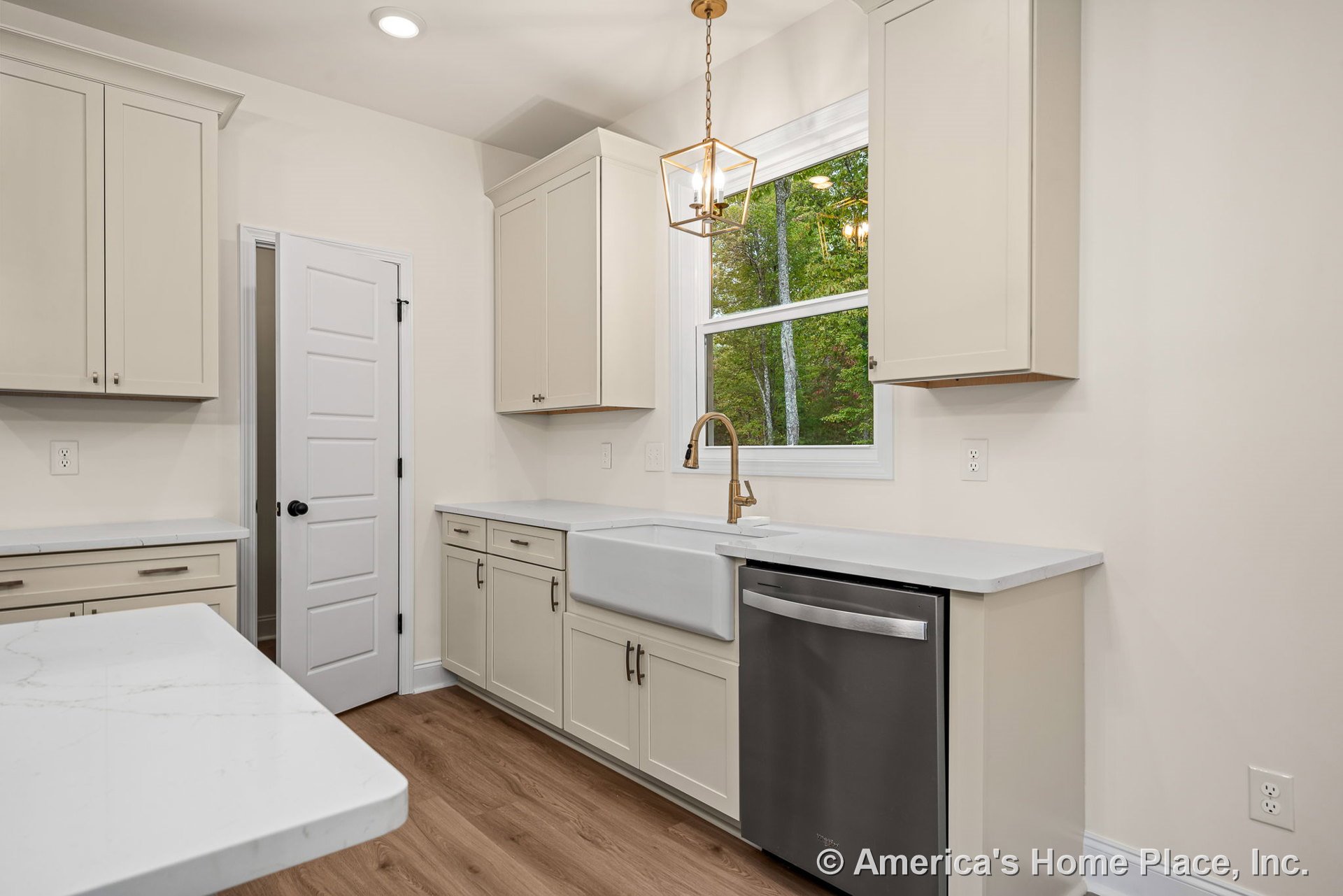 Shaker-style cabinets with quartz countertops, farmhouse sink, stainless steel dishwasher, wood-look flooring, pendant light fixture, window with trim, and neutral color palette.