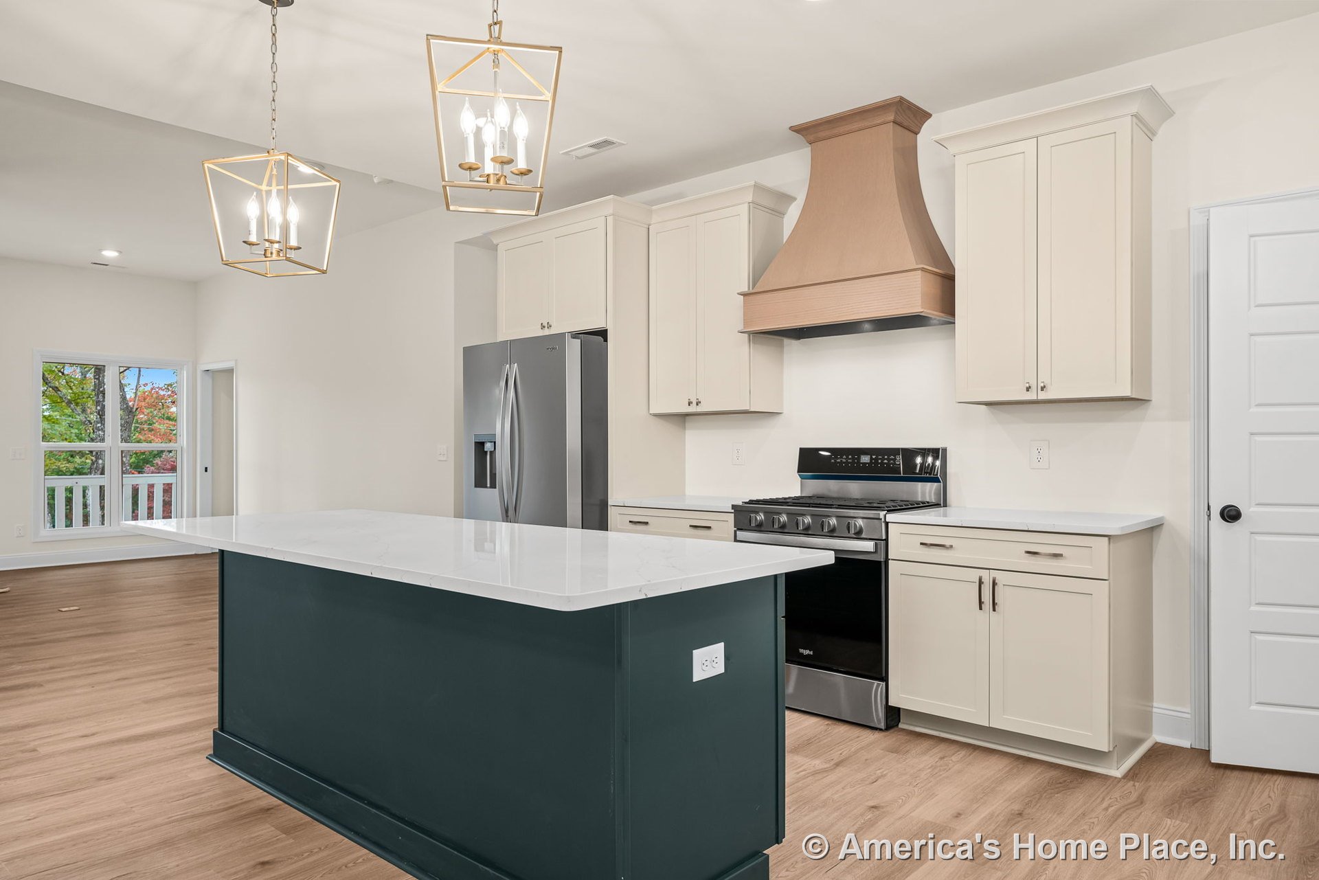 Shaker-style cabinetry, large quartz island countertop, wood range hood, stainless steel appliances, pendant ceiling lights, wide plank wood flooring, windows with trim.