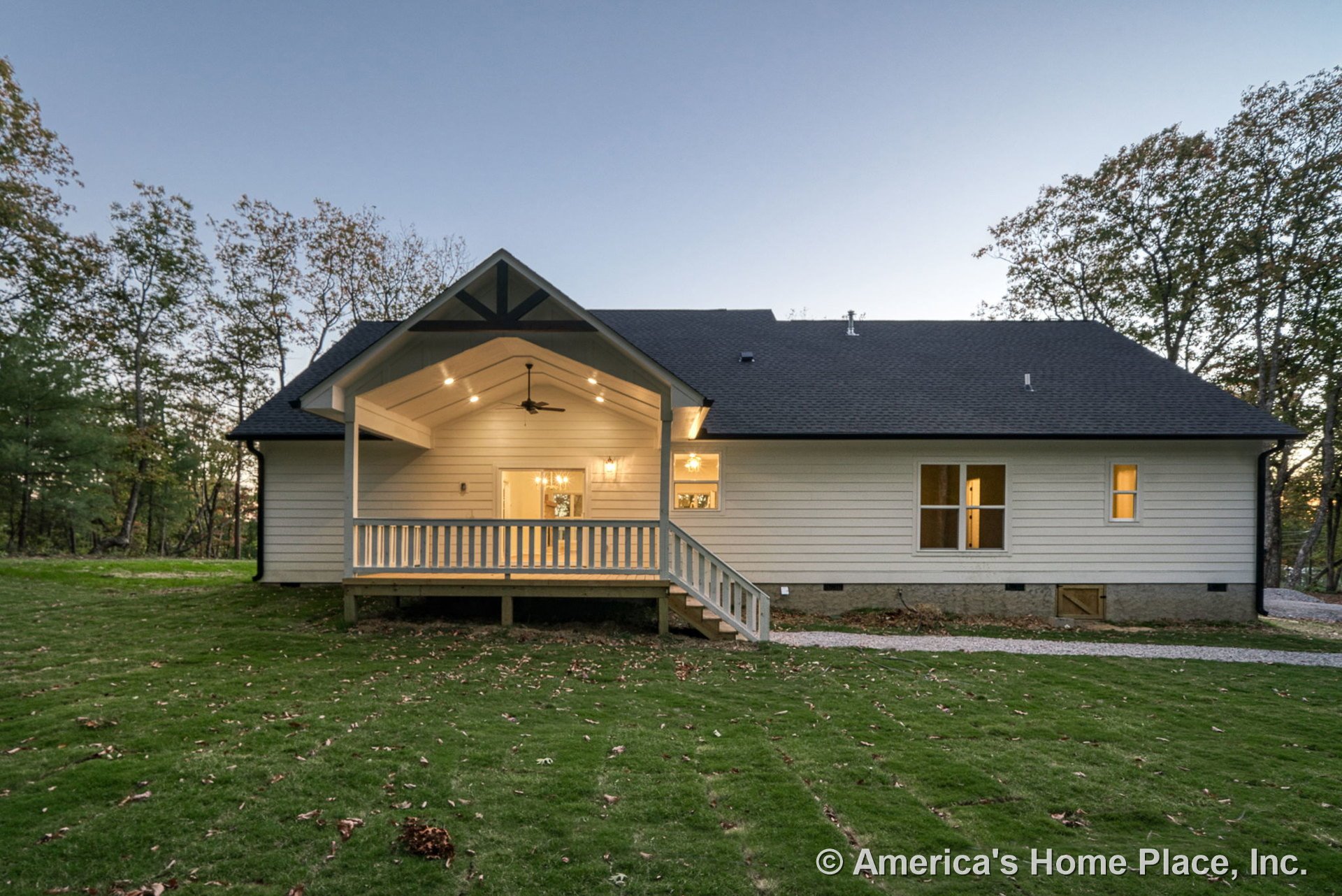 Covered back porch with vaulted ceiling featuring exposed beam, recessed lighting, and ceiling fan; horizontal lap siding exterior with multiple double-hung windows, decorative