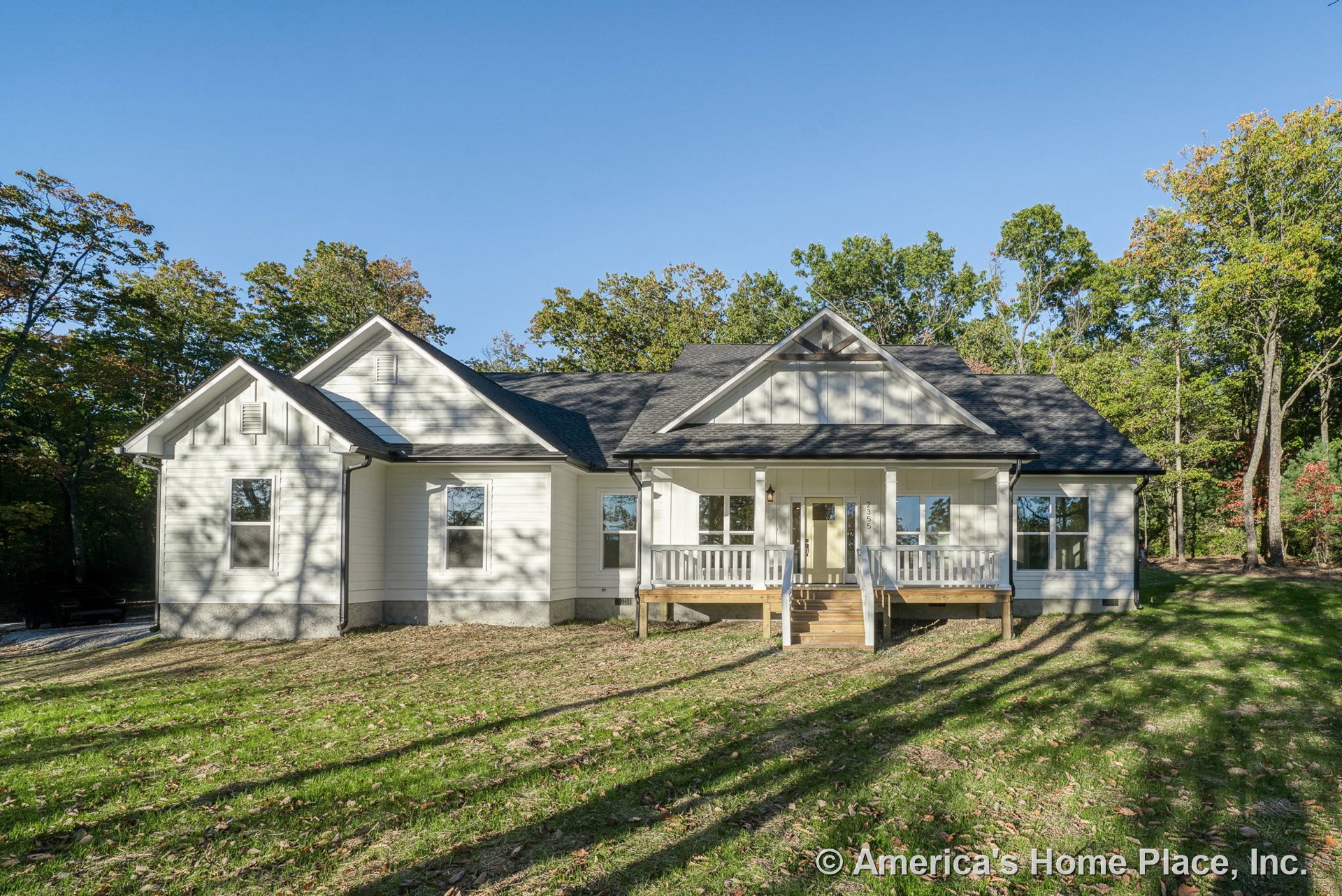 Covered front porch with white railings, wooden steps, white horizontal siding, multiple gable roofs, large double-hung windows, and trimmed exterior corners at the front entry.