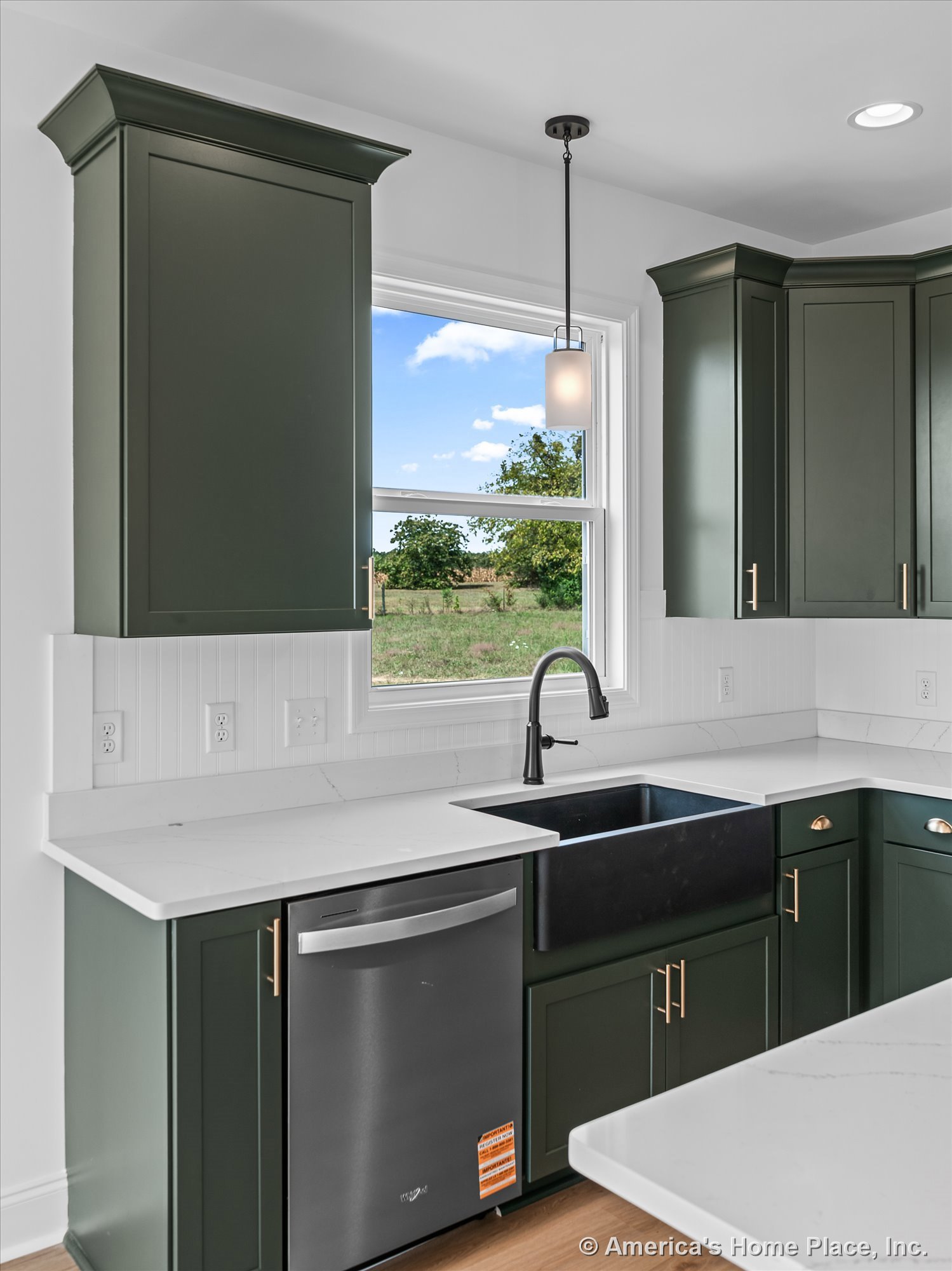Dark green upper cabinets and white quartz countertops with a black farmhouse sink beneath a large window, beadboard backsplash, matte black faucet, stainless steel dishwasher