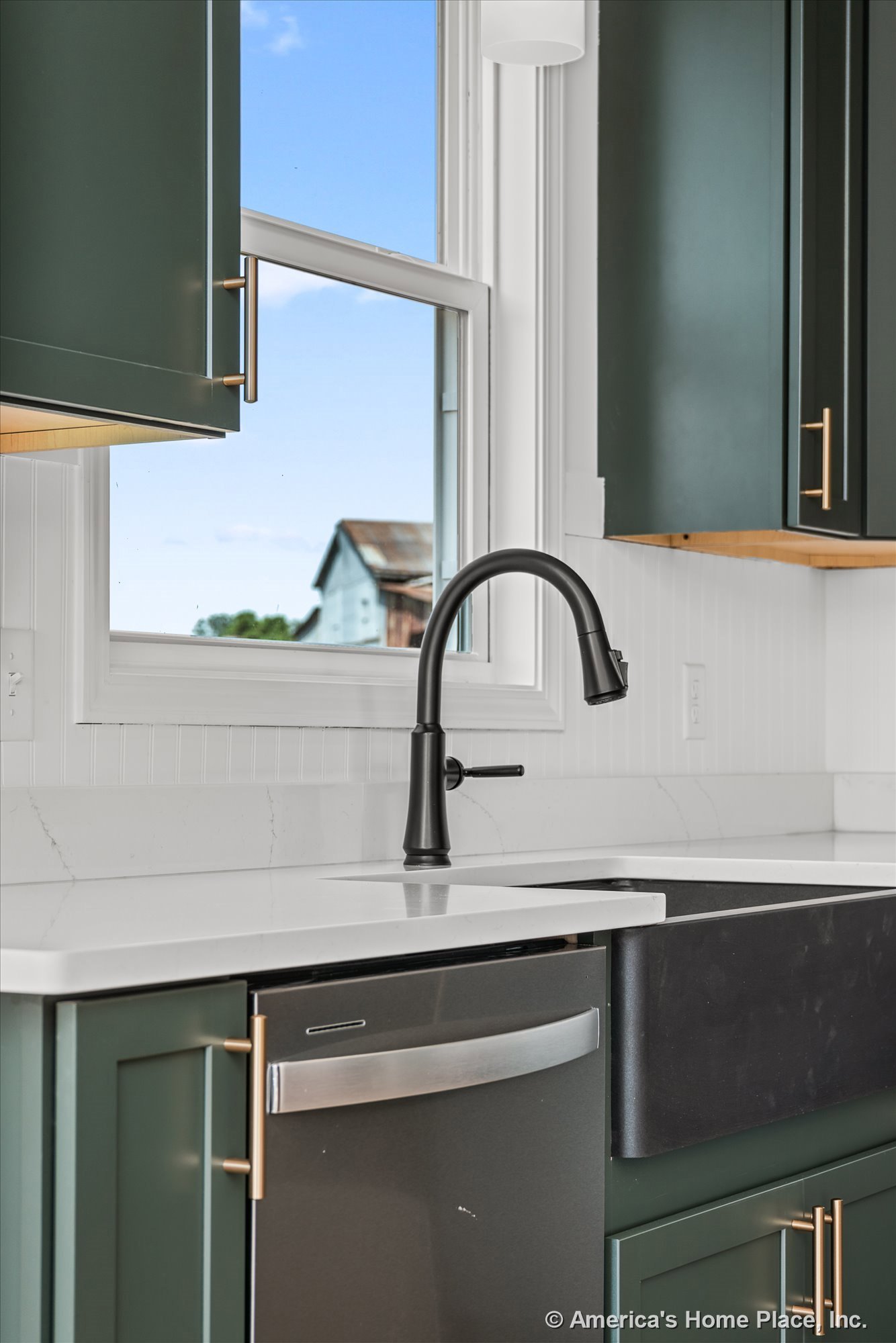 Green shaker cabinets with gold hardware, white quartz countertops, black farmhouse sink and matte black faucet set beneath a window, built-in dishwasher, white trim, modern