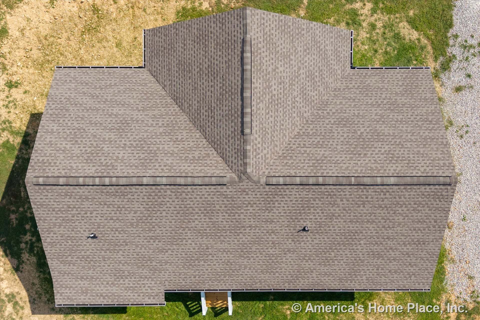 Aerial perspective of a residential home featuring a multi-gabled asphalt shingle roof with visible roof vents, eaves, gutters, and a covered porch roof section; exterior context