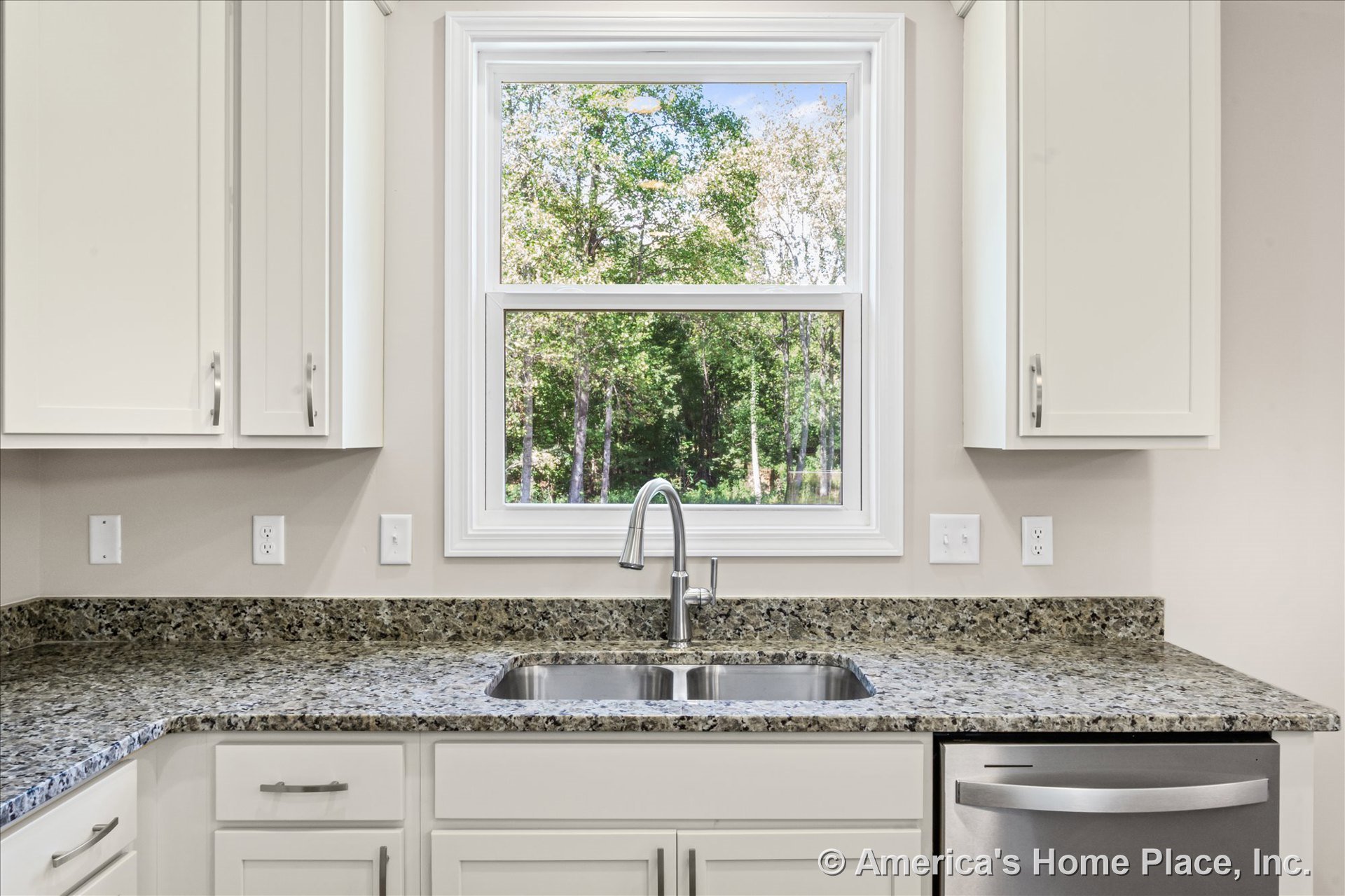 Granite countertops with white shaker cabinets, double-basin stainless steel sink set beneath a large window with trim, built-in dishwasher, multiple electrical outlets, and modern