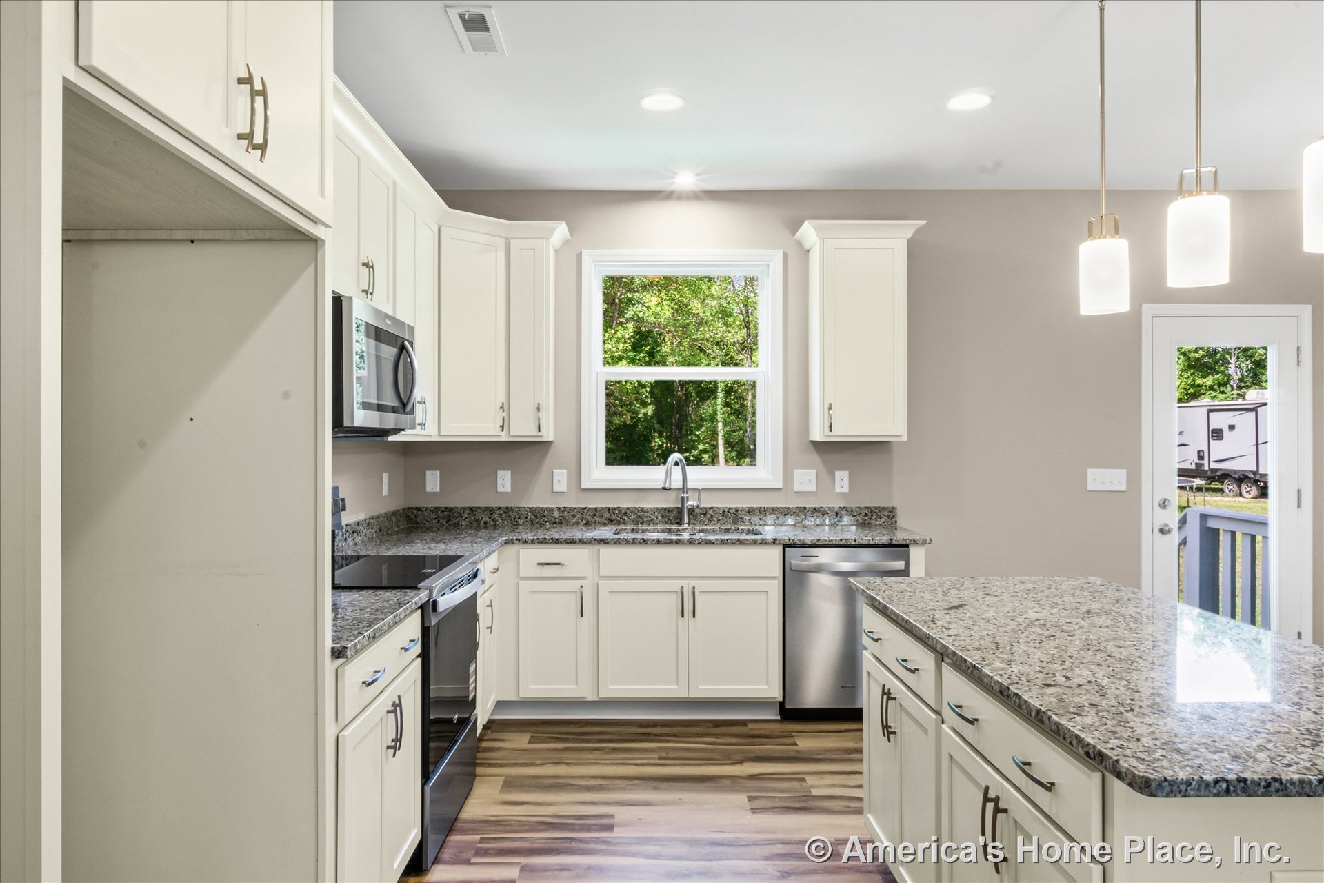 Cream shaker cabinets and granite countertops with a central kitchen island, stainless steel dishwasher and built-in microwave, electric range, large window above the sink, pendant