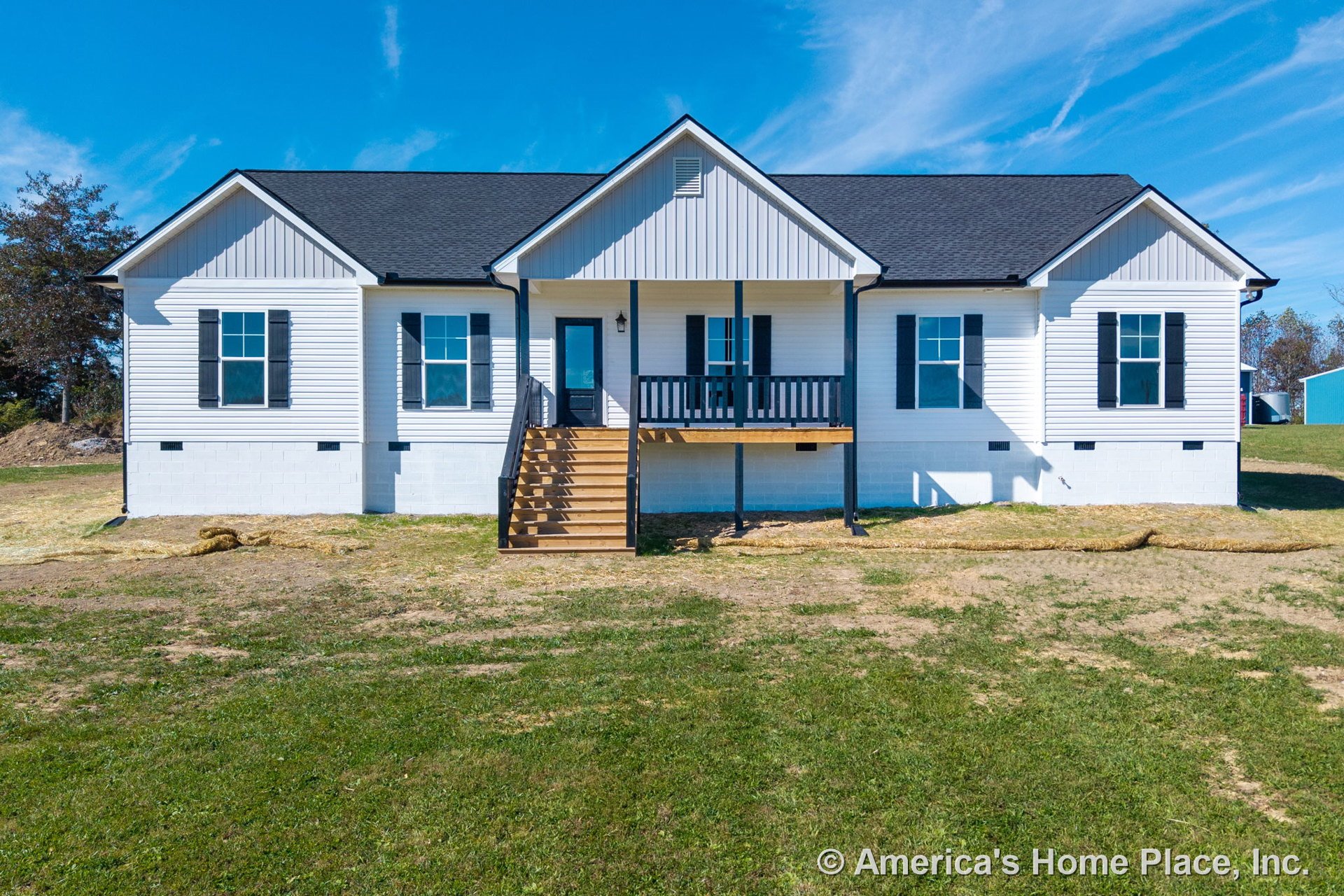 Covered front porch with wooden steps and black railings, white siding exterior, black shutters on windows, gabled roof, and black front door with contrasting trim.