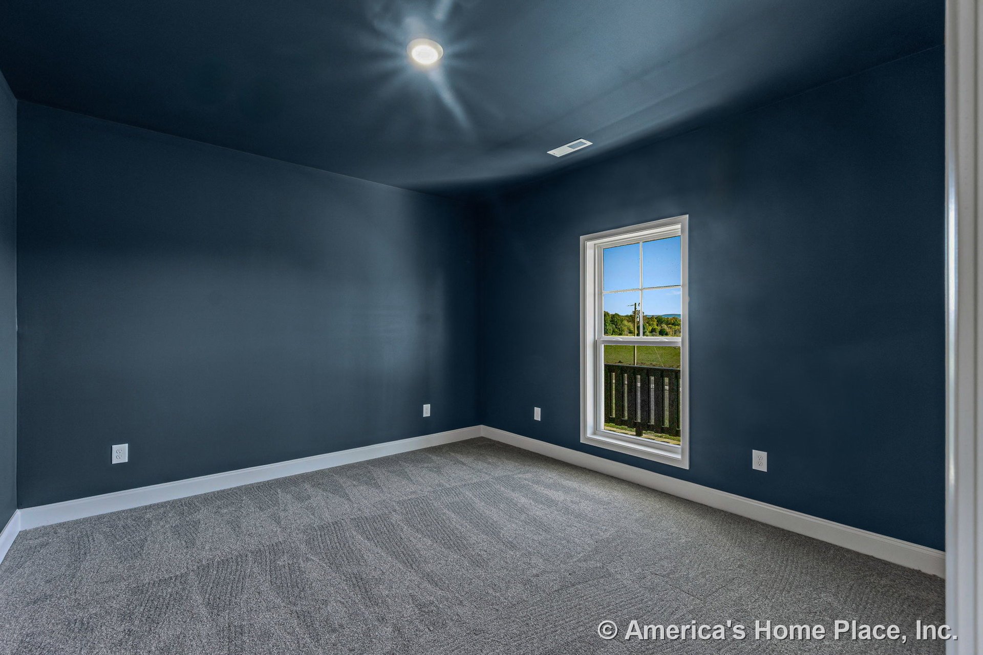 Bedroom with dark blue walls, white trim and baseboards, single window with white frame, light gray carpet flooring, recessed ceiling light, rectangular layout, and modern